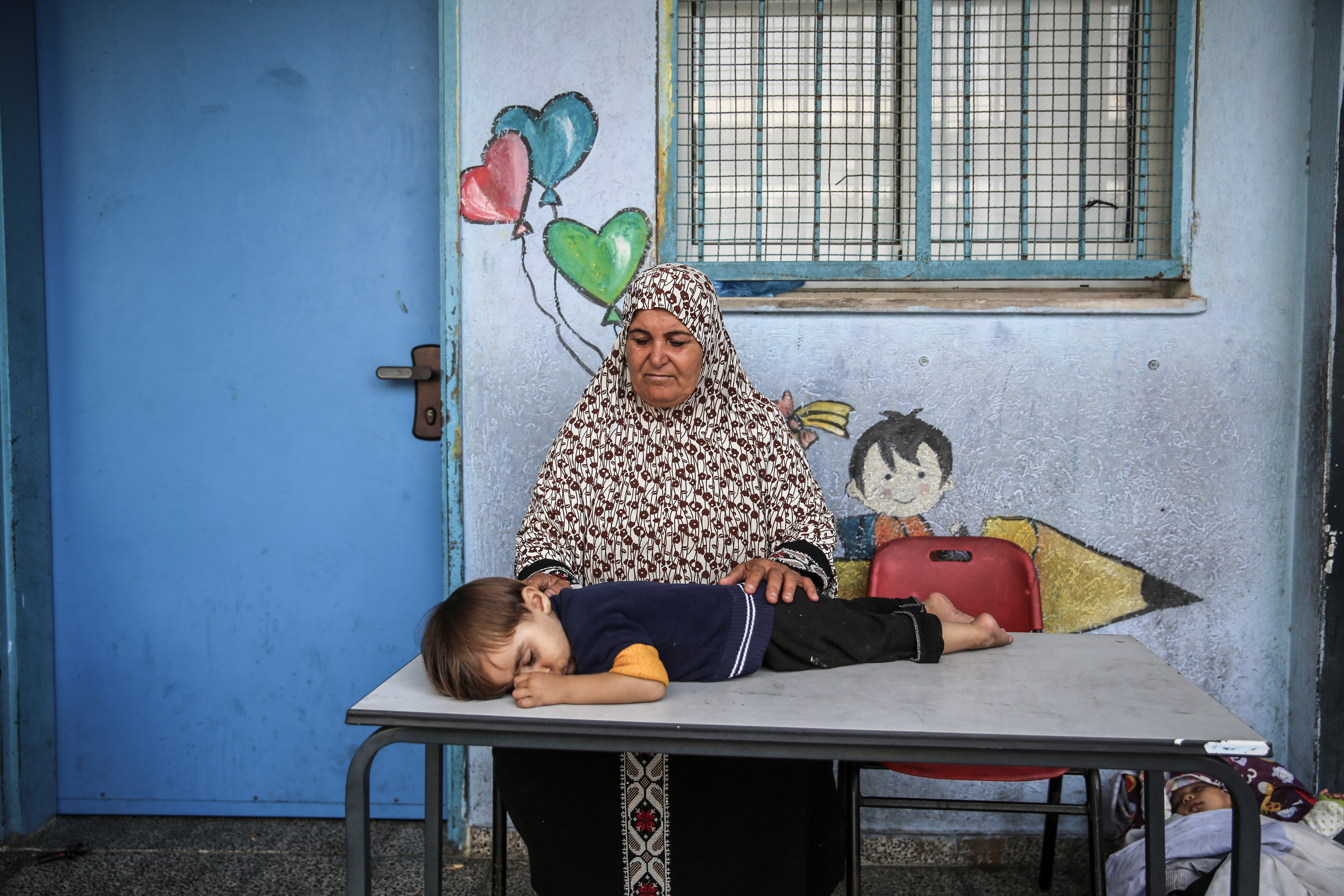 A Palestinian grandmother sits with her grandchild in an UNRWA classroom