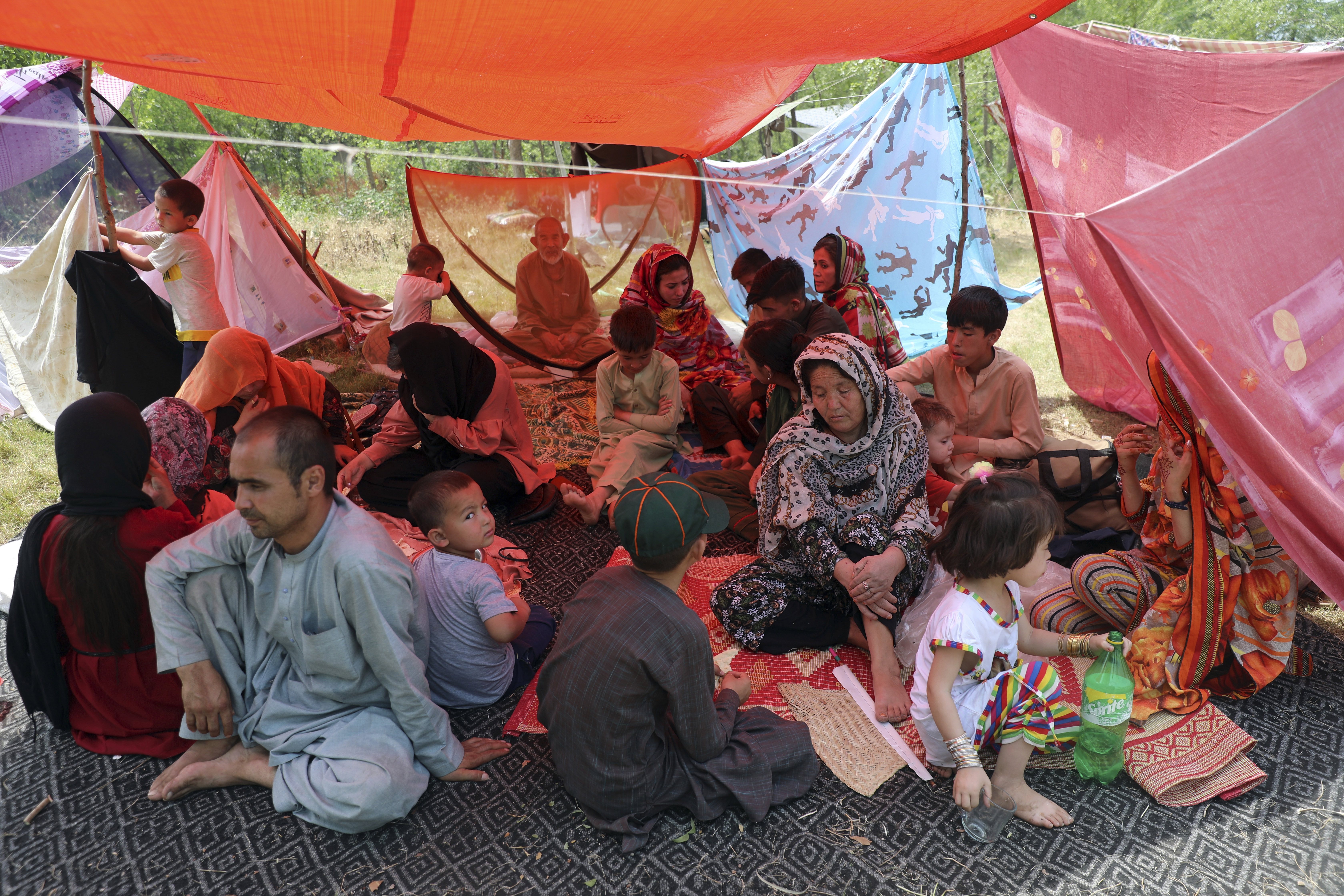 Afghan people rest as they have put up makeshift tents on the ground seeking to receive asylum from the United Nations High Commissioner for Refugees (UNHCR) outside the Islamabad Press Club in Islamabad, Pakistan, Monday, May 9, 2022. (AP Photo/Rahmat Gul)