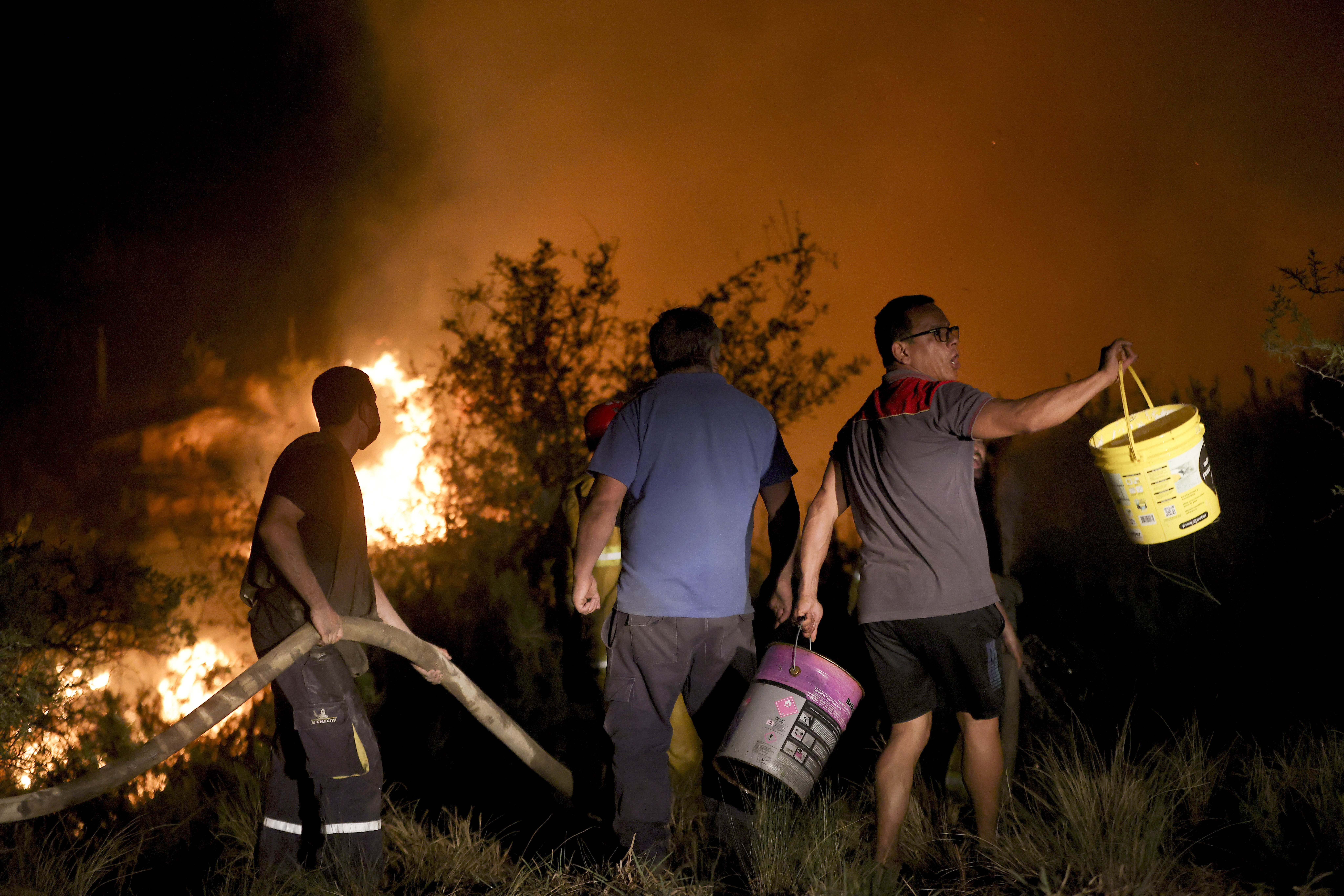 Neighbors work to put out a forest fire