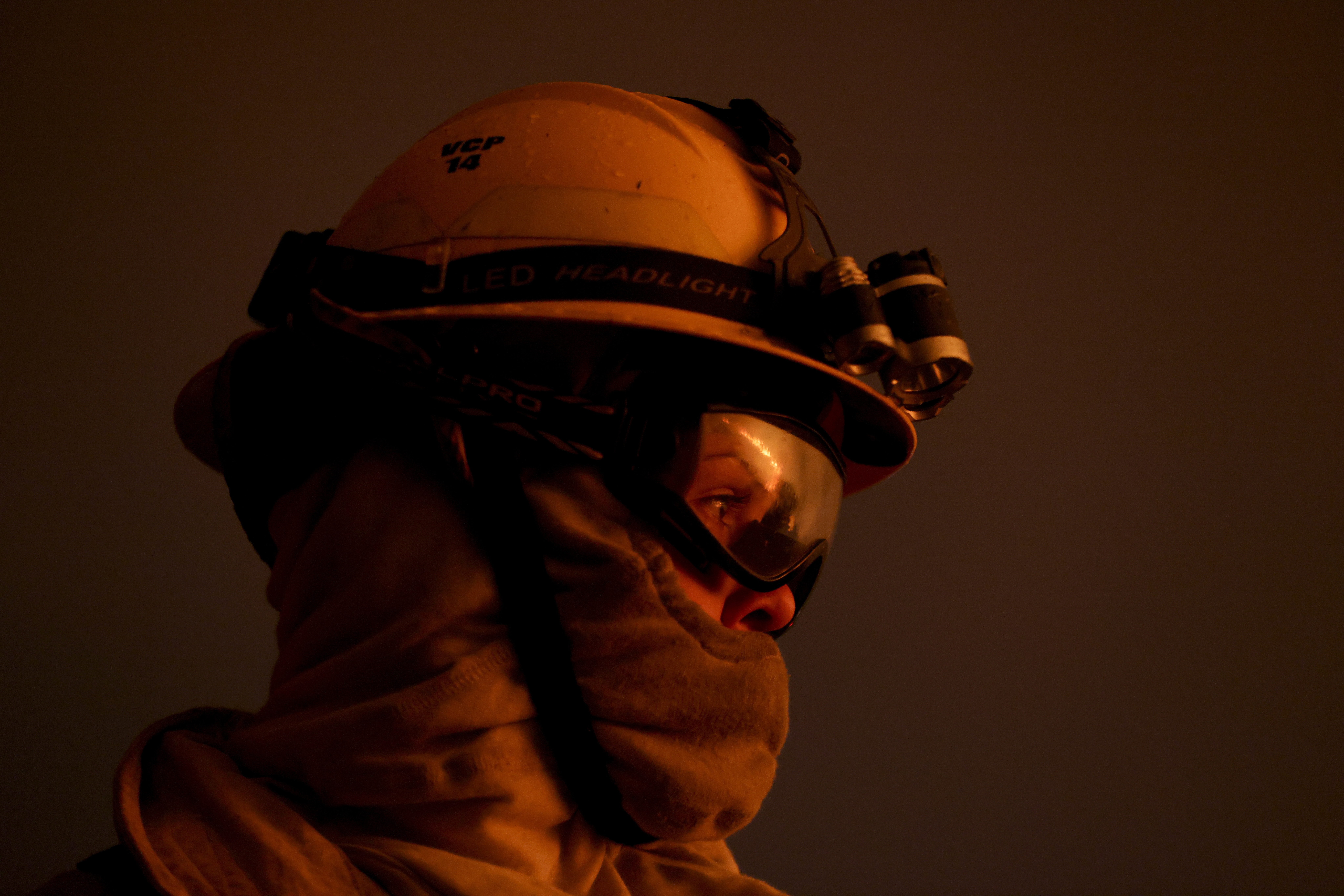 A firefighter watches the flames of a forest fire on the outskirts of Villa Carlos Paz