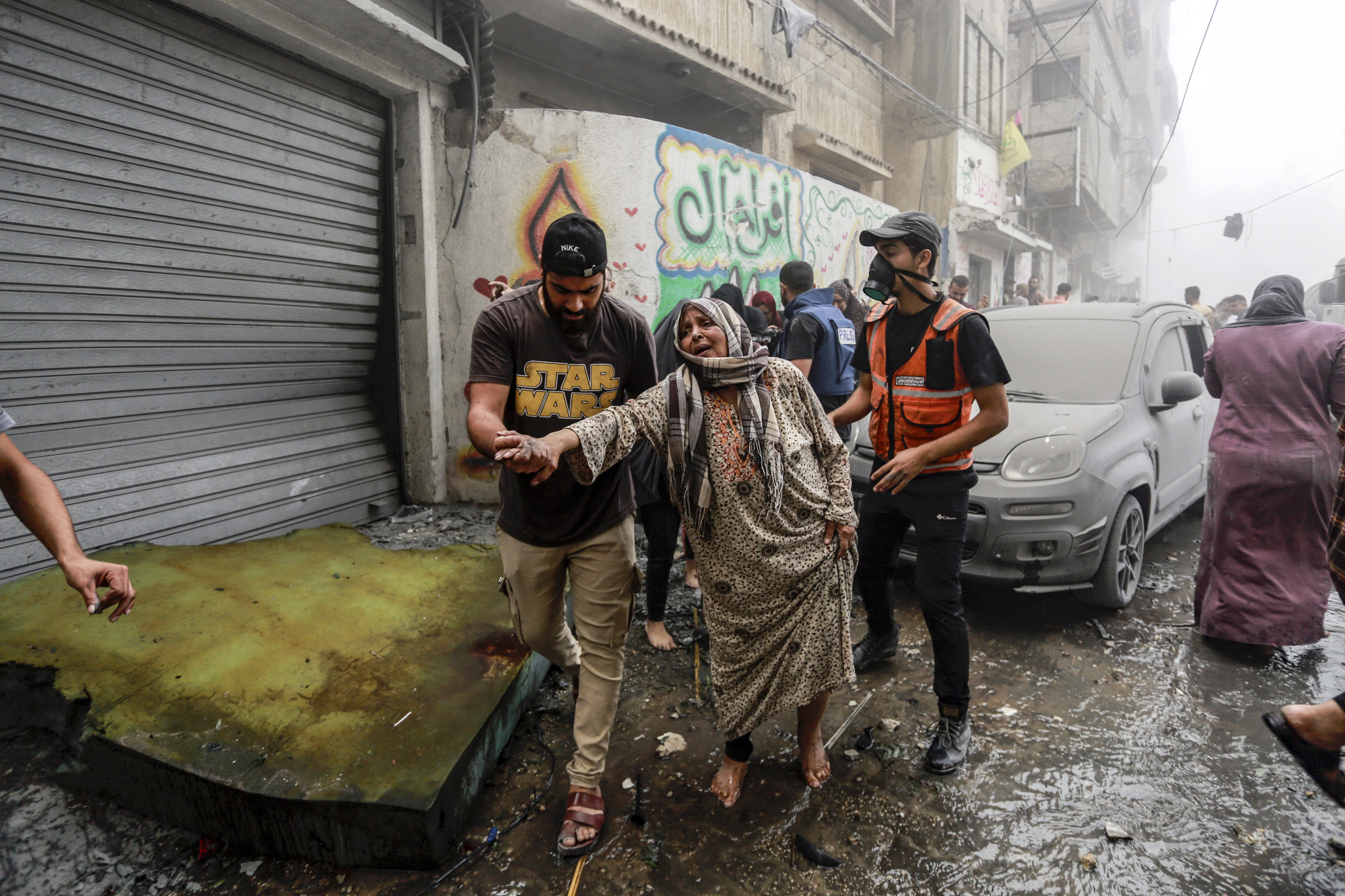 People help evacuate a Palestinian woman following Israeli airstrikes that targeted her neighbourhood in Gaza City