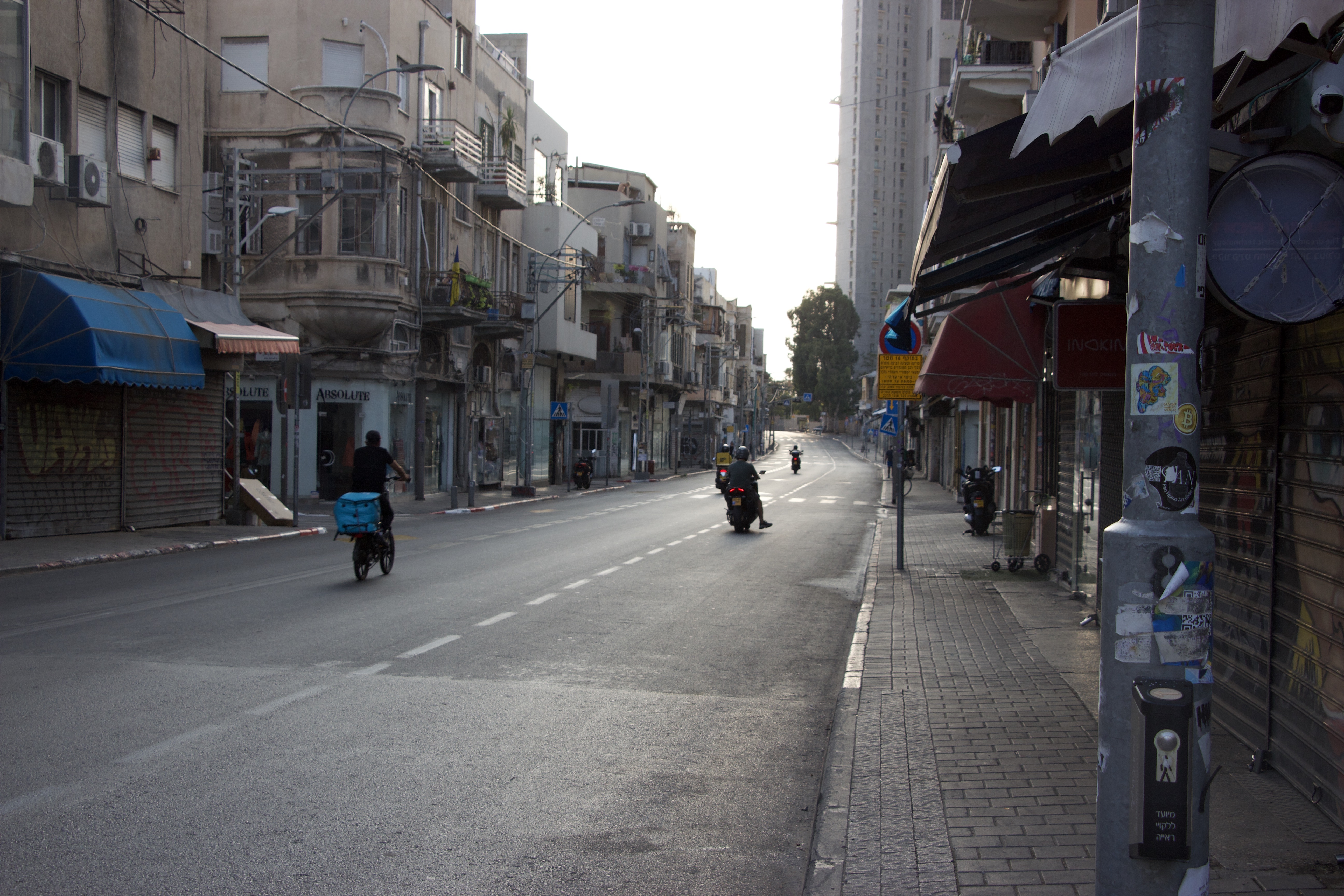 Delivery scooters speed down empty streets in Tel Aviv