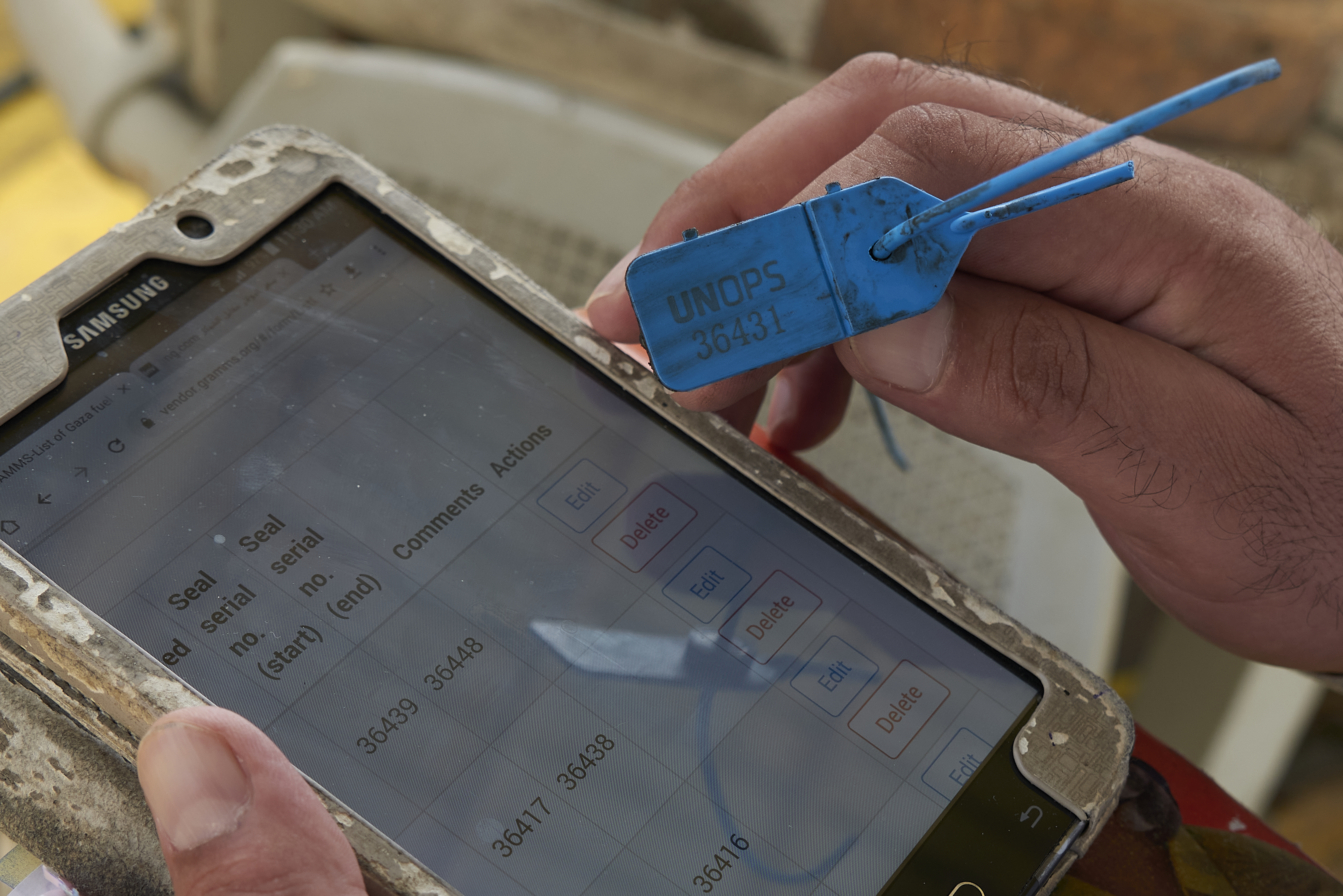 A UN inspector scrolls through the list of serial numbers for the scheduled delivery tags which prevent any tampering with the fuel before it arrives at its destination.