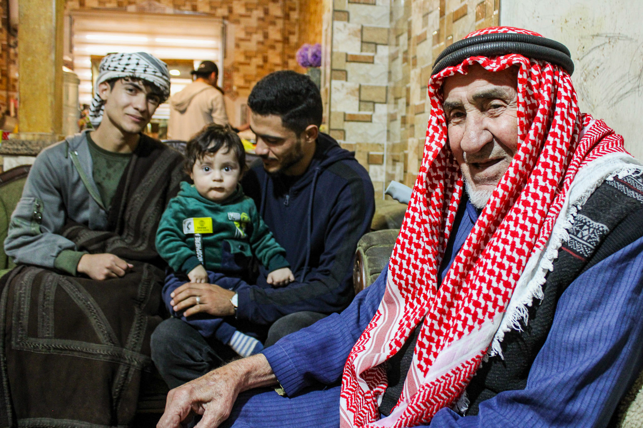 Mohammad Nashwan (left wearing keffiyeh), baby Tayem, Tayem's father and Saadi's son, Souhayb, and Abdullah [Hanna Davis/Al Jazeera]