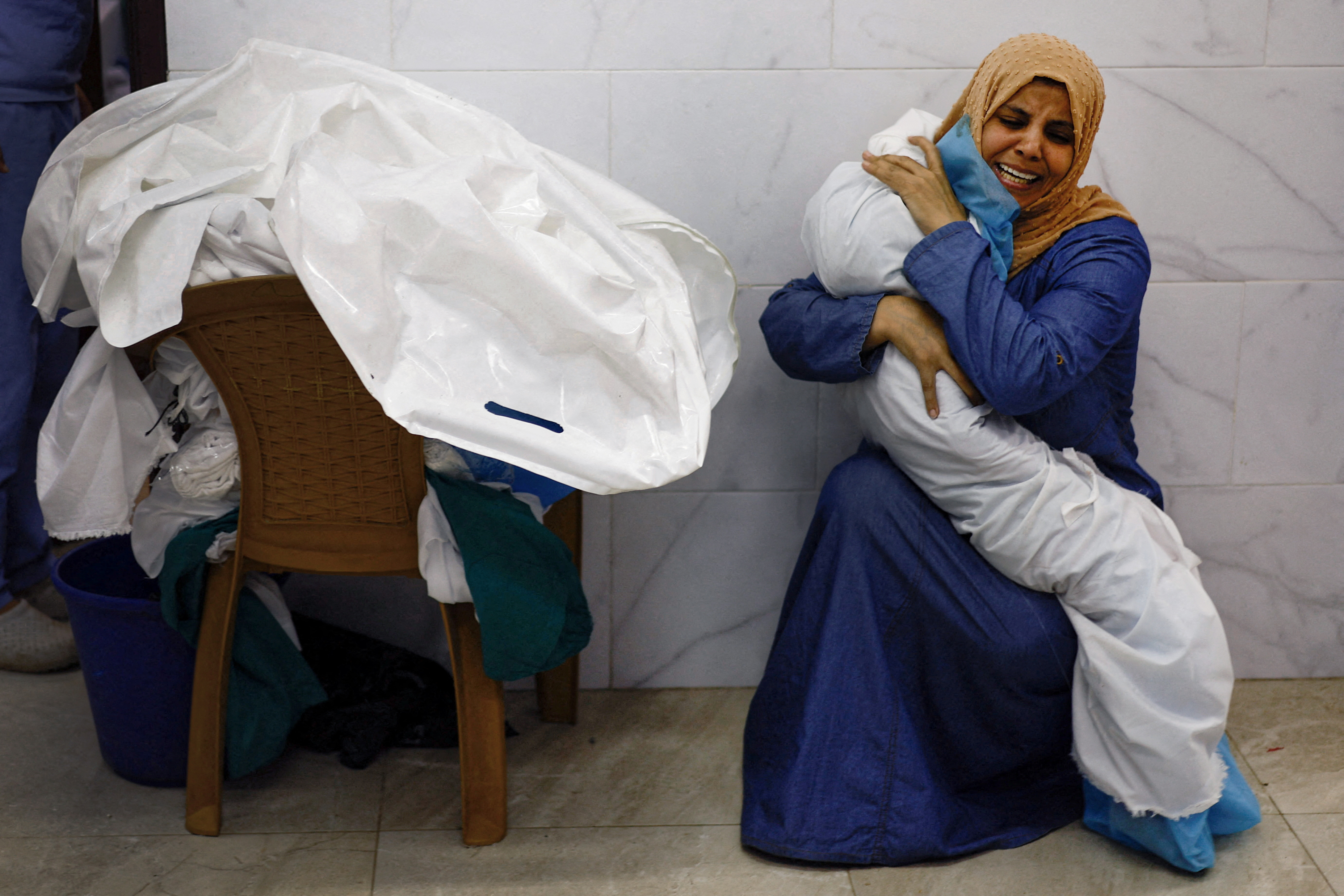 Palestinian woman Inas Abu Maamar, 36, embraces the body of her 5-year-old niece Saly, who was killed in an Israeli strike, at Nasser hospital in Khan Younis in the southern Gaza Strip.