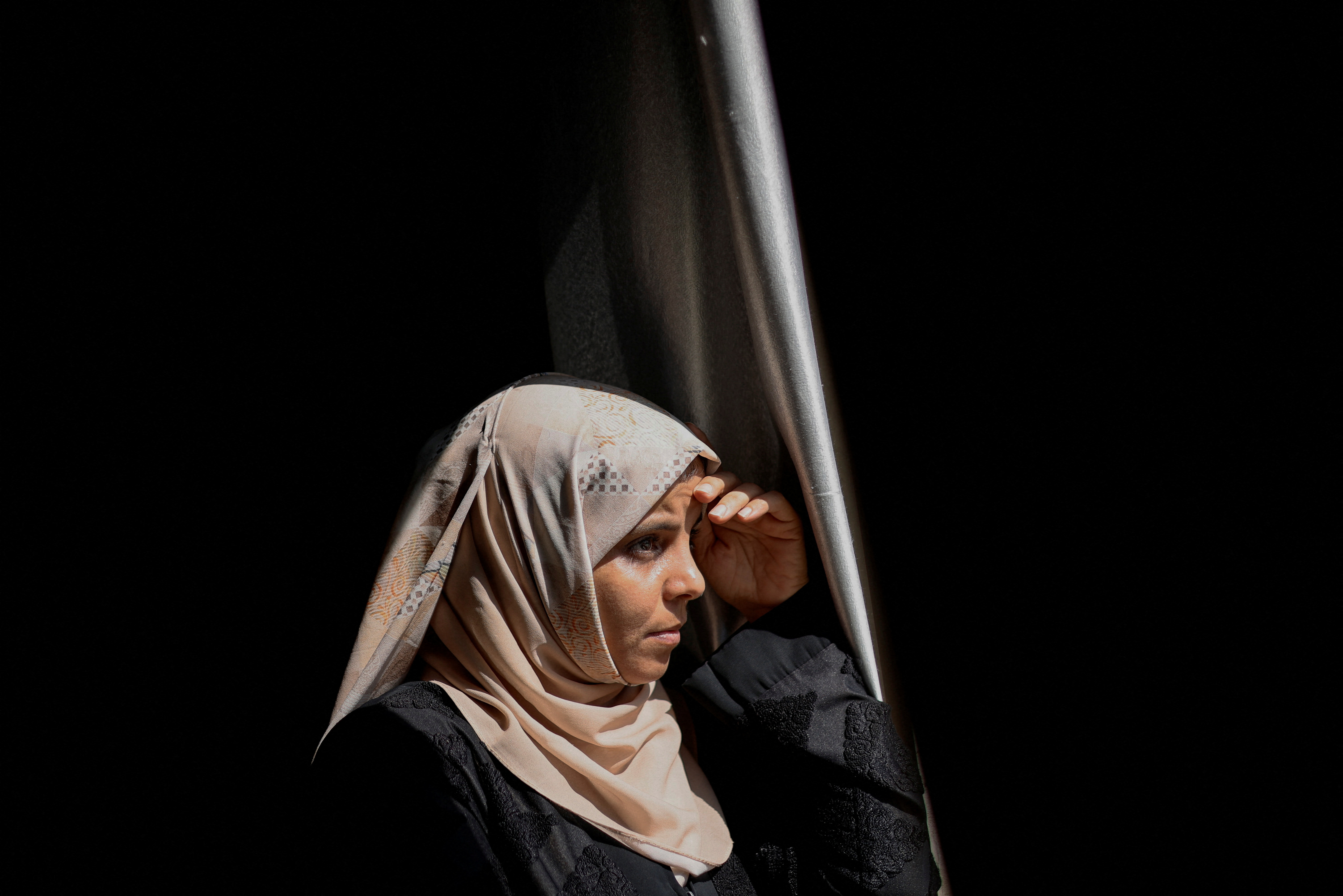 Palestinian woman Inas Abu Maamar, 36, whose picture embracing the body of her 5-year-old niece Saly who was killed in an Israeli air strike went viral on local and international media, looks out of her house, in Khan Younis in the southern Gaza Strip.