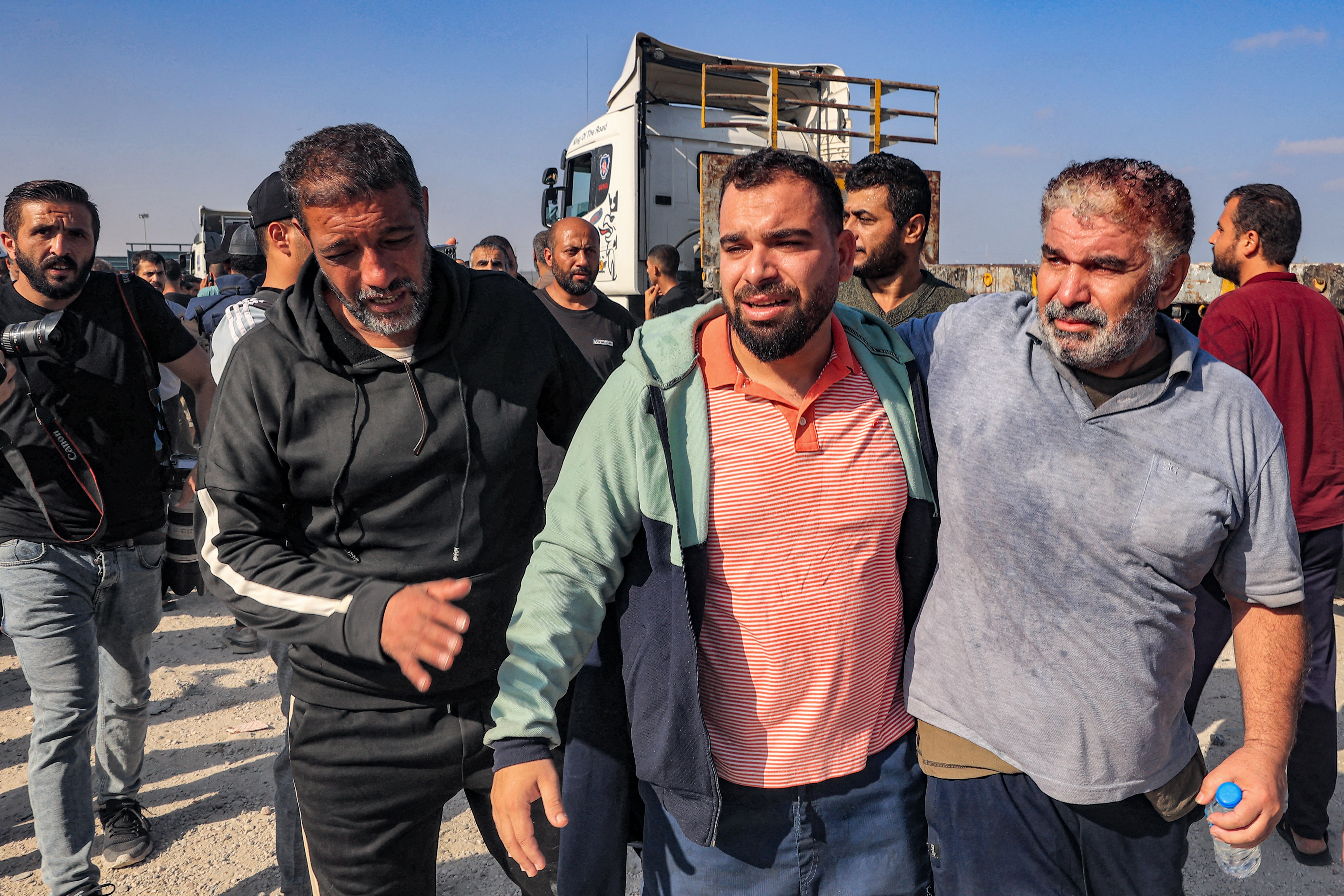 Palestinian workers, who were stranded in Israel since the October 7 attacks, are received as they cross back into the Gaza Strip at the Kerem Shalom commercial border crossing with Israel in the south of the Palestinian enclave on November 3, 2023