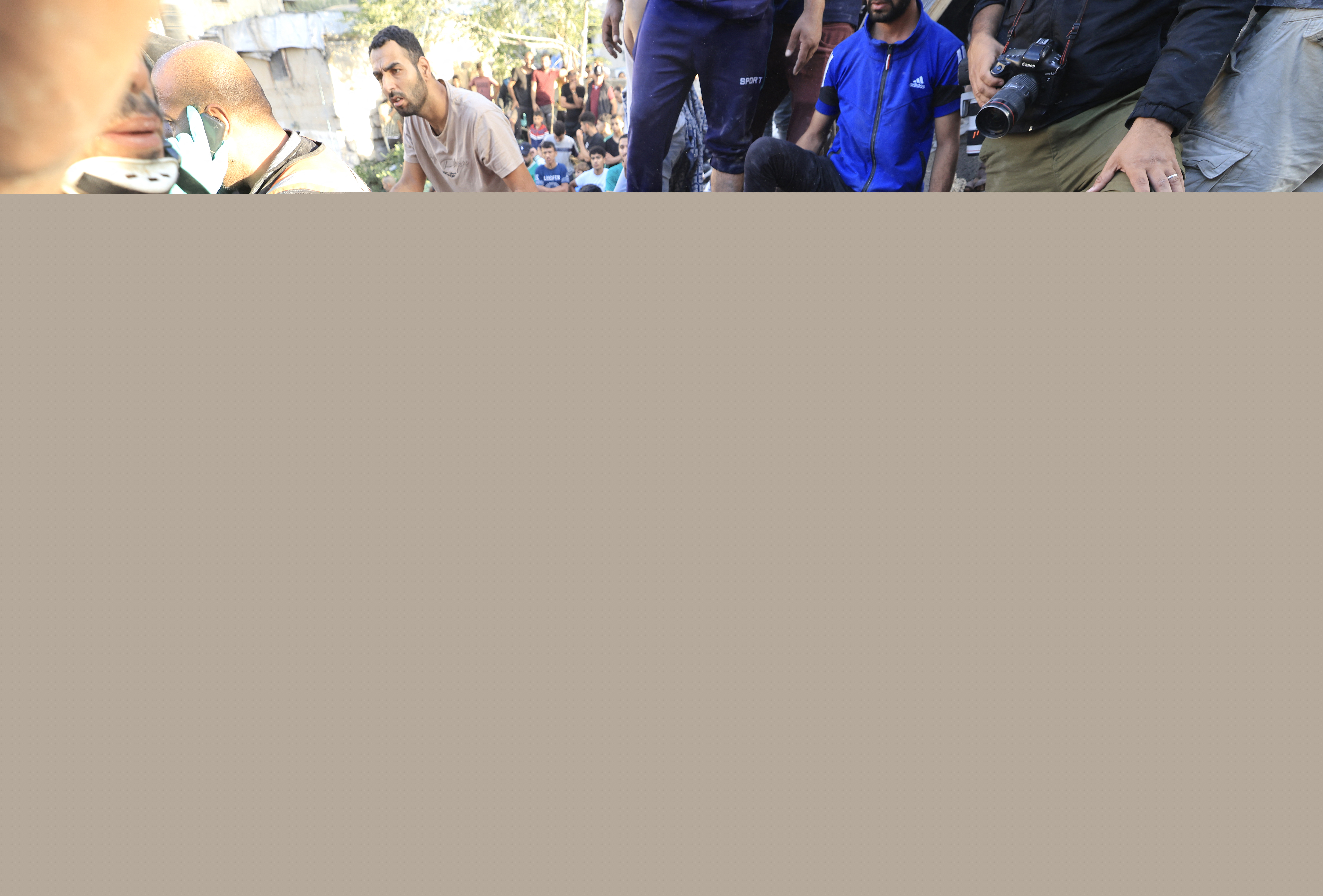 A Palestinian woman sits on the rubbles as rescuers look for her relatives following the Israeli bombardment of Khan Yunis
