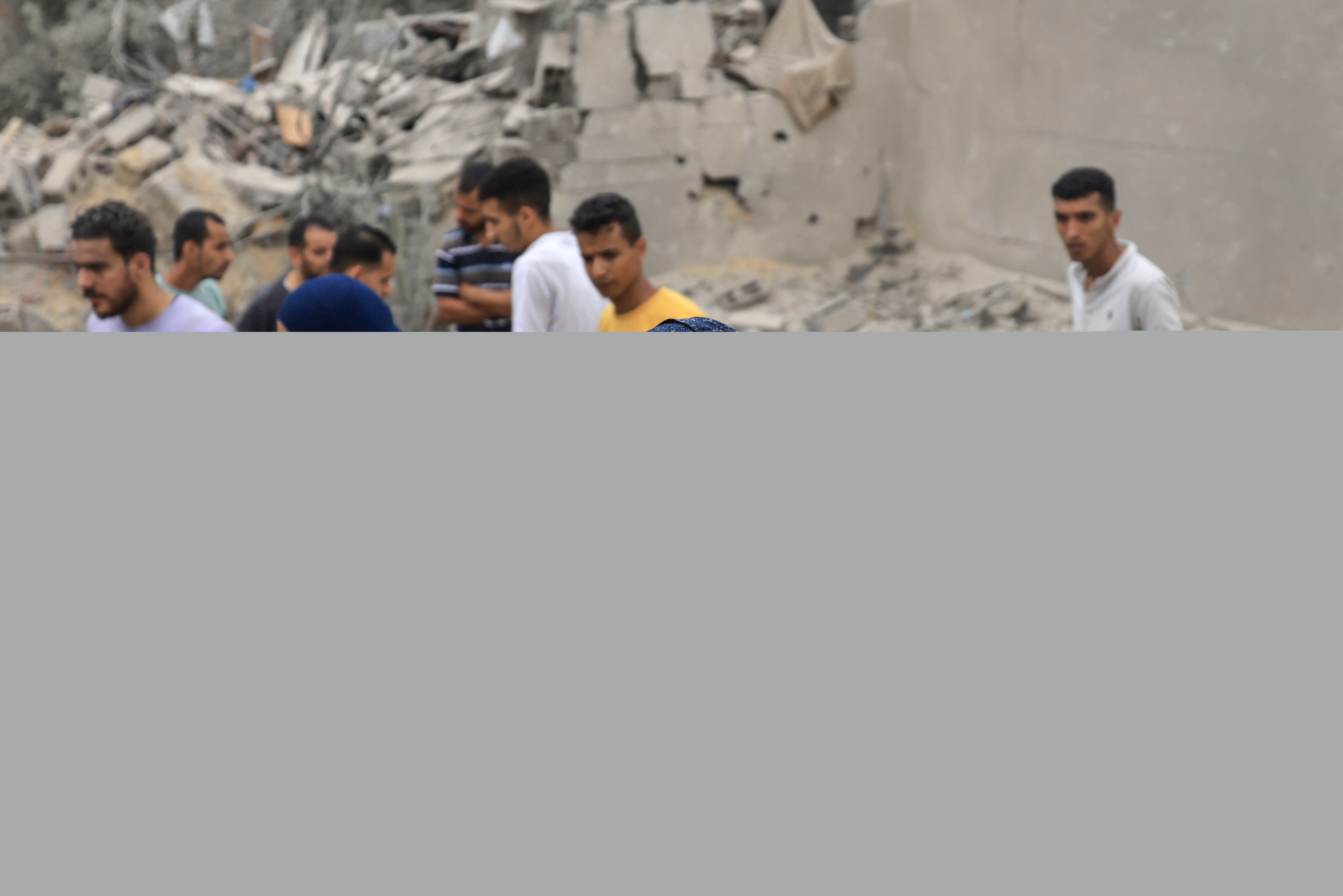 A woman reacts as people stand amid the rubble of a destroyed building following an Israeli bombardment in Khan Yunis in the southern Gaza Strip.