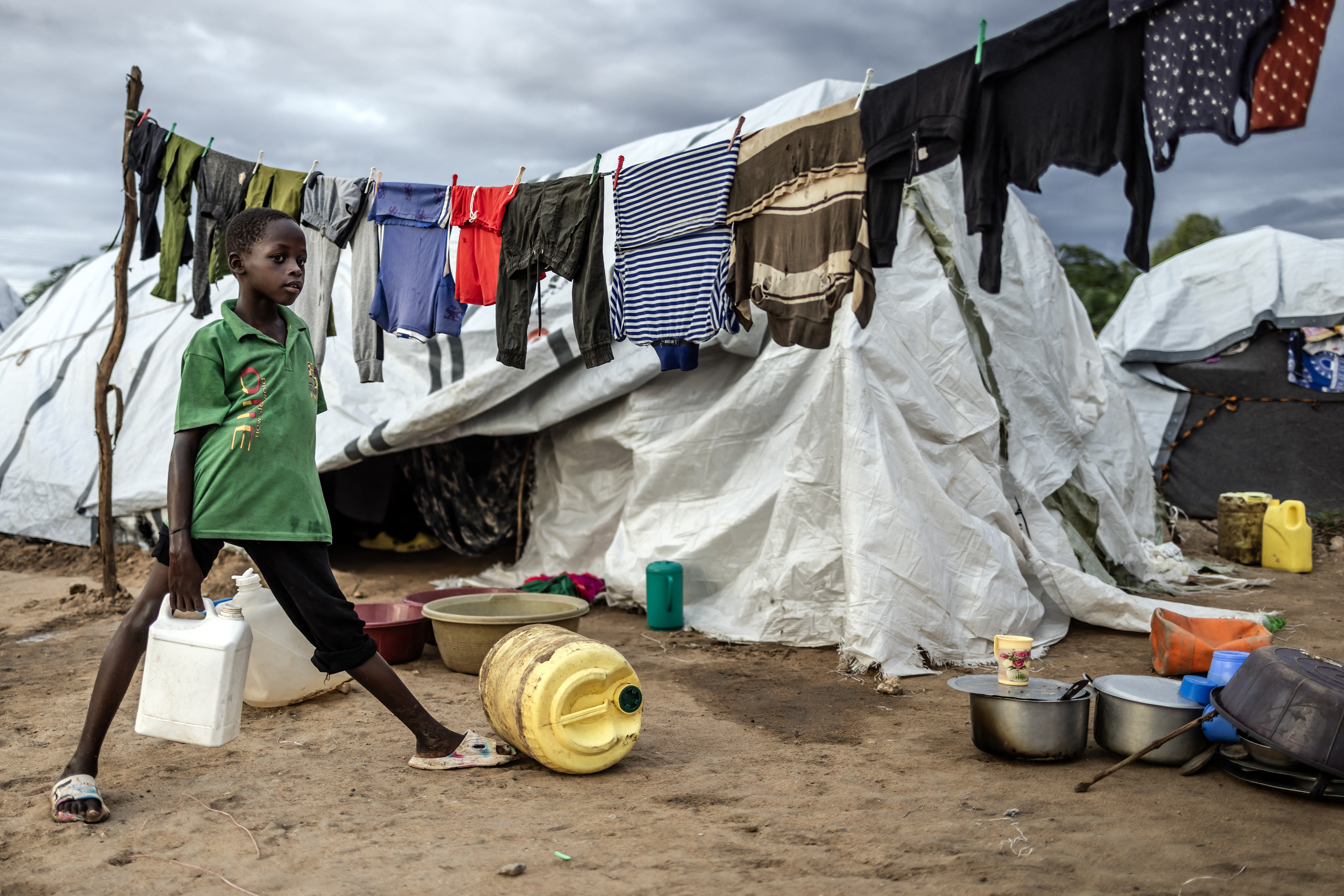 A boy carries water next to the tent where he lives with his family at an internally displaced persons (IDP) camp for families displaced by floods in Garissa.
