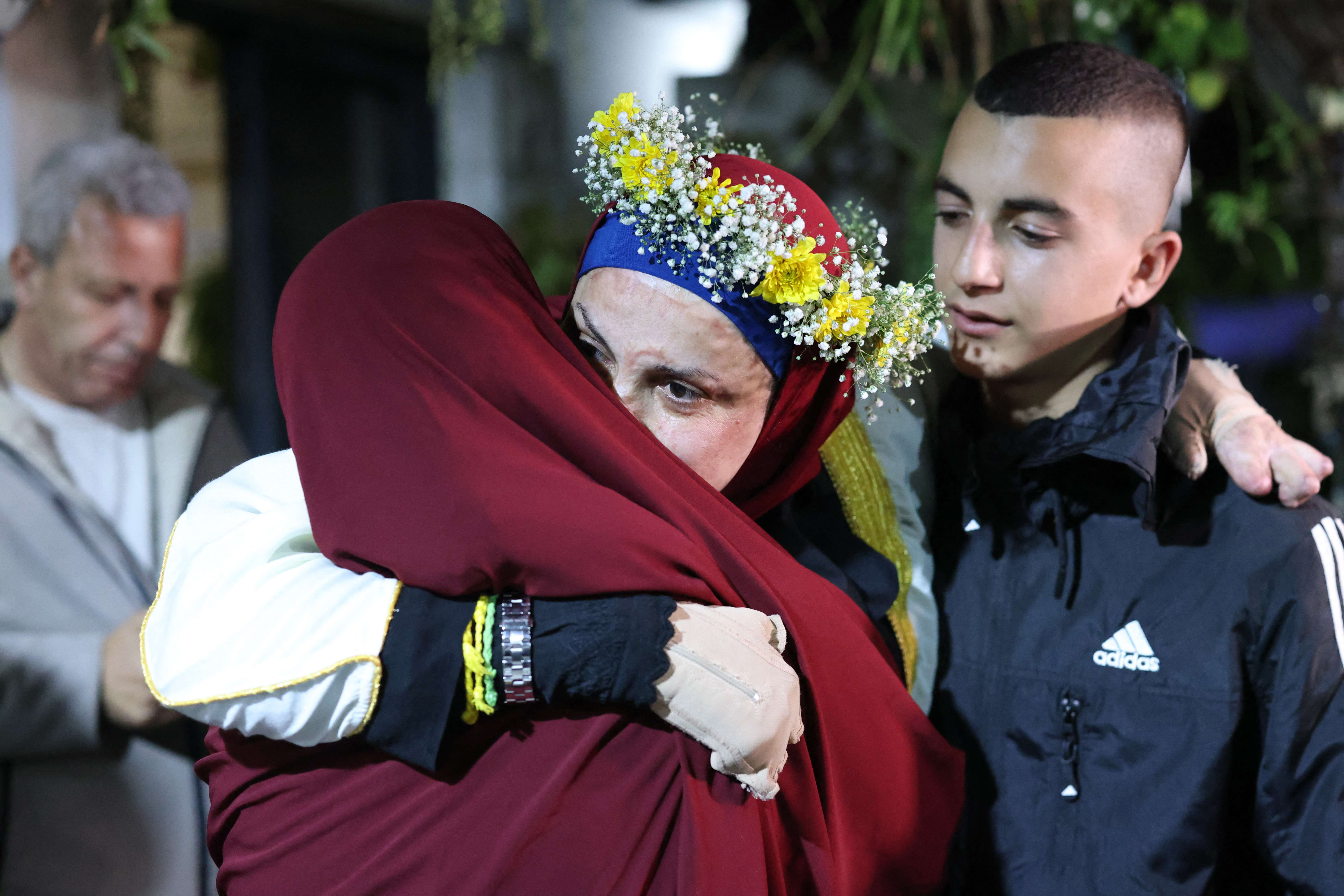 Relatives of prominent Palestinian prisoner Israa Jaabis (C) welcome her at her home in Israeli-annexed east Jerusalem early on November 26, 2023, after detainees were released from Israeli jails in exchange for hostages released by Hamas from the Gaza Strip