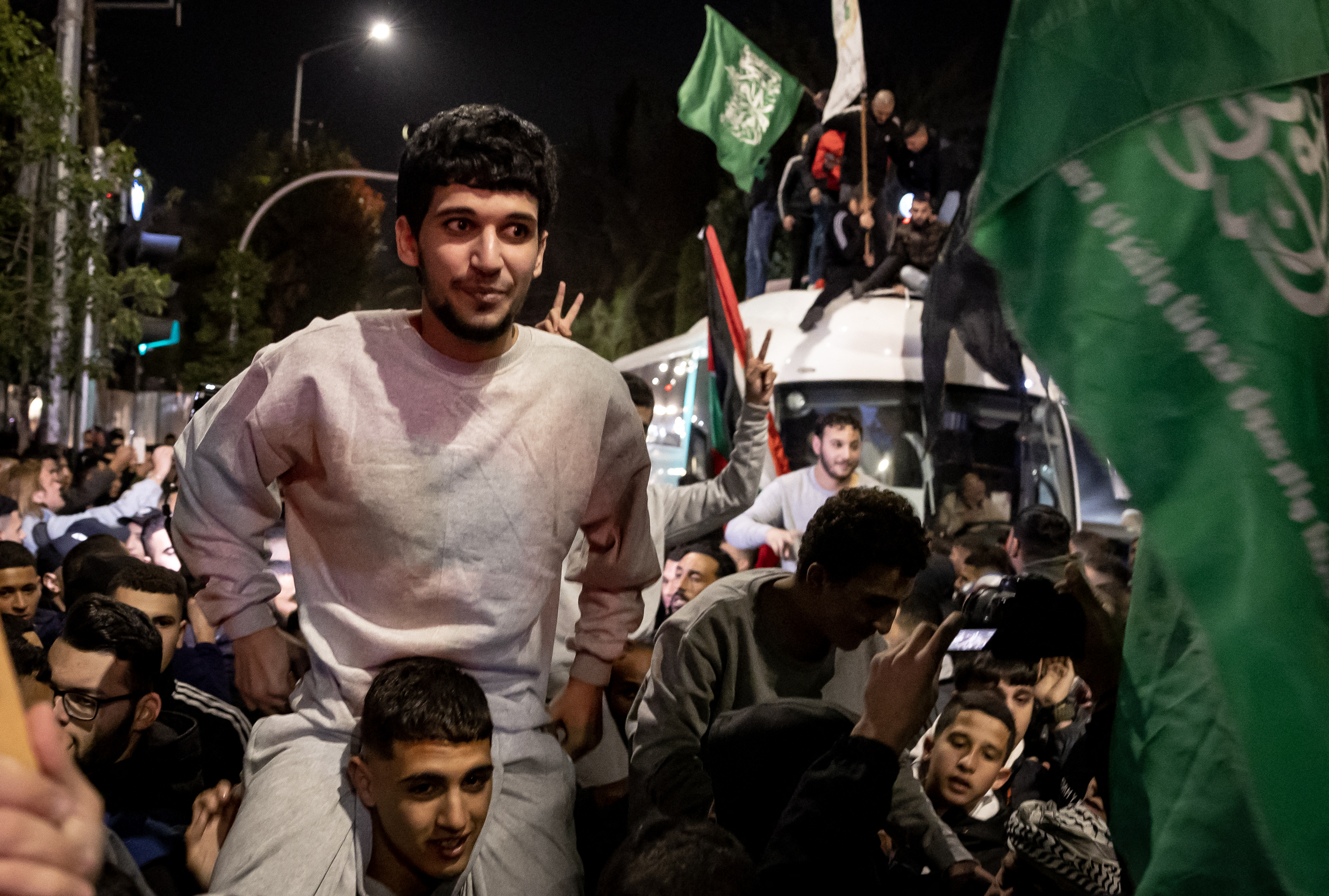Palestinian prisoners (wearing grey jumpers) cheer among supporters and relatives after being released from Israeli jails.