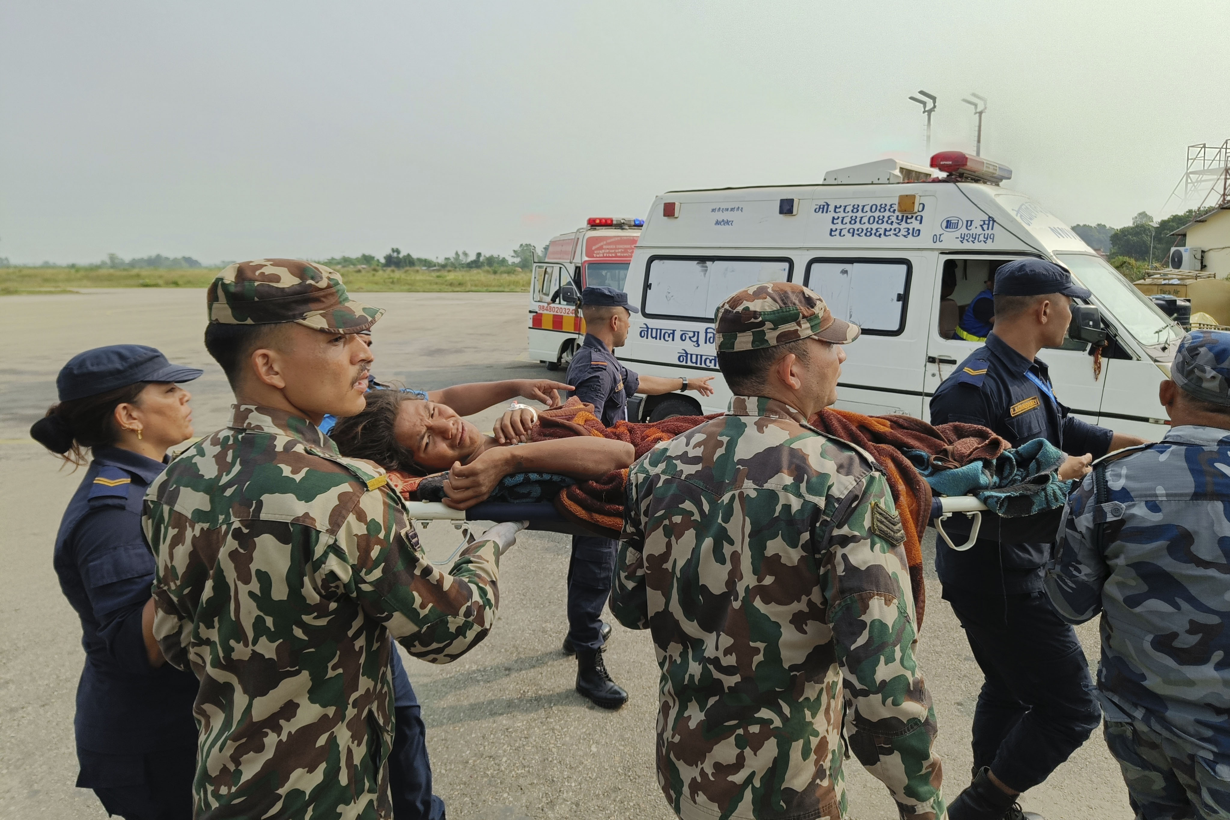 A woman airlifted from an earthquake-affected area is carried on a stretcher in Nepalgunj, Nepal, Saturday