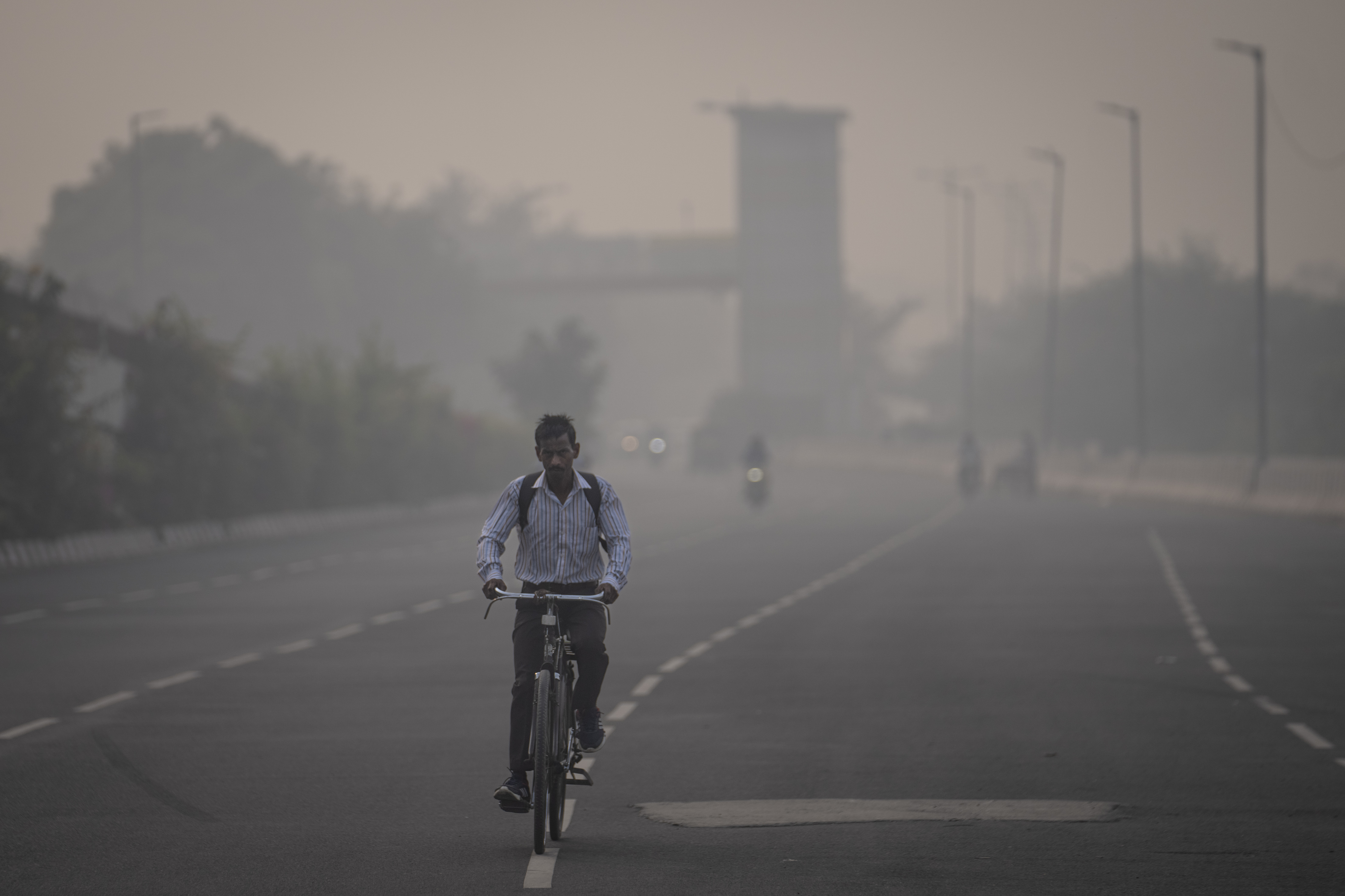 A cyclist rides amid smog in New Delhi, India, Tuesday, Nov. 7, 2023. Masks are back on the streets as residents of the capital city grapple with the annual surge in air pollution that has engulfed the region.