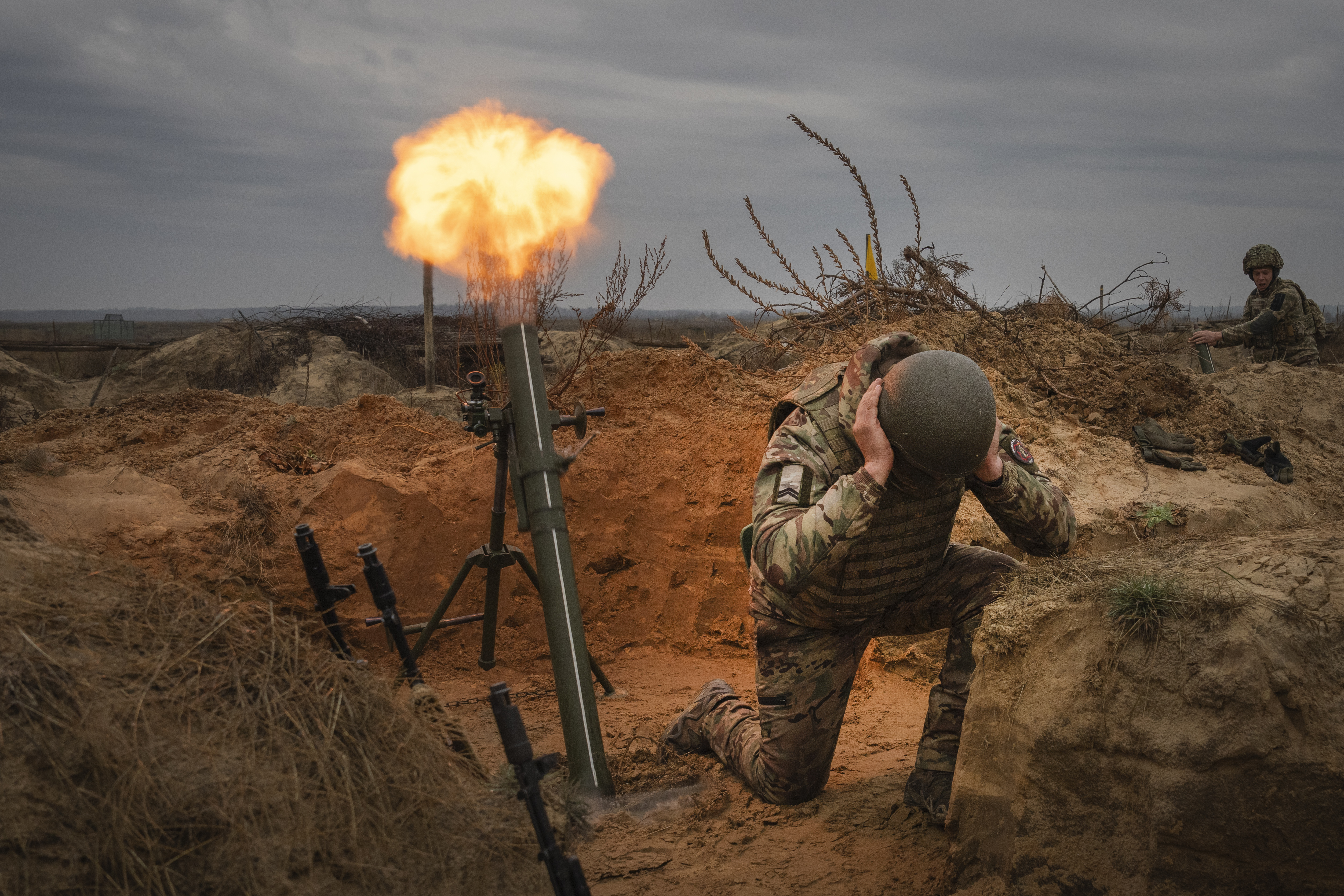 Ukraininan soldiers on combat training. They are turning away and covering their ears after firing a weapon.