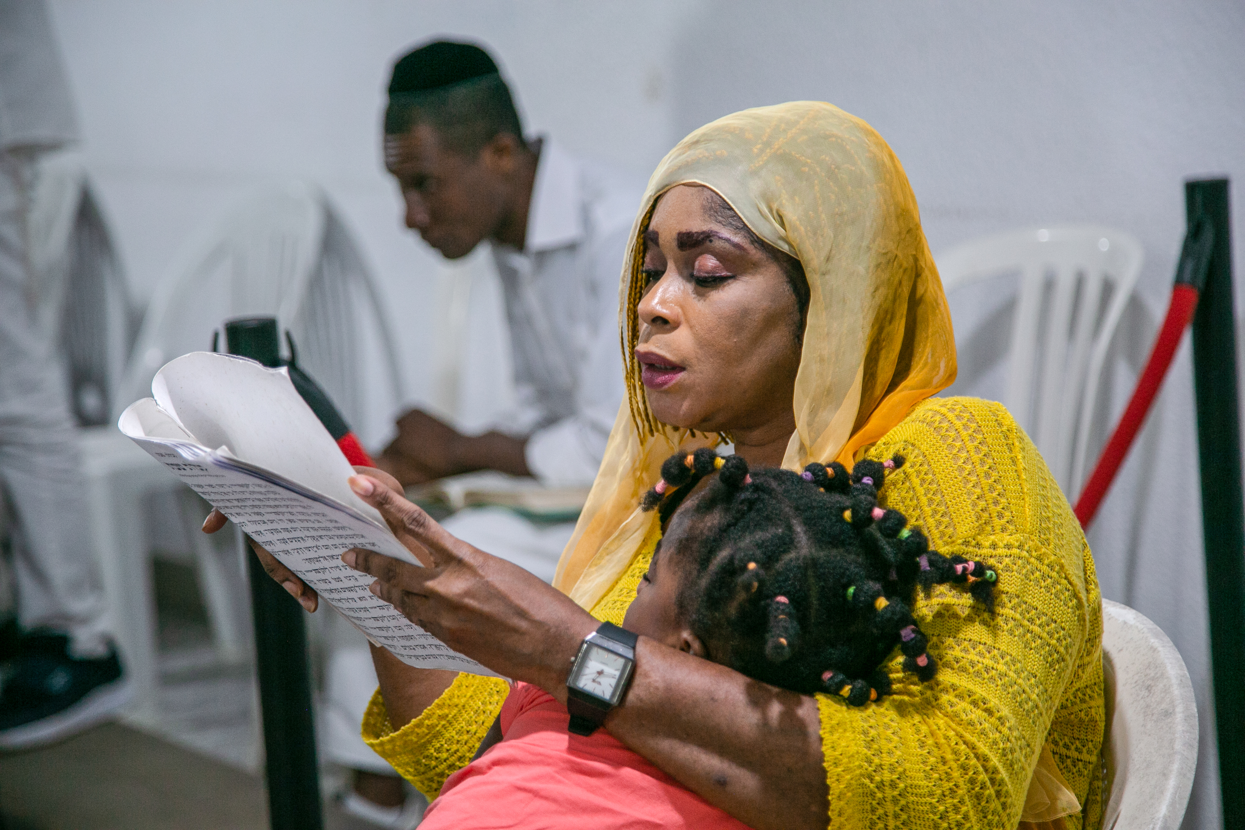 A woman reads the prayers in Hebrew during Shabbat services
