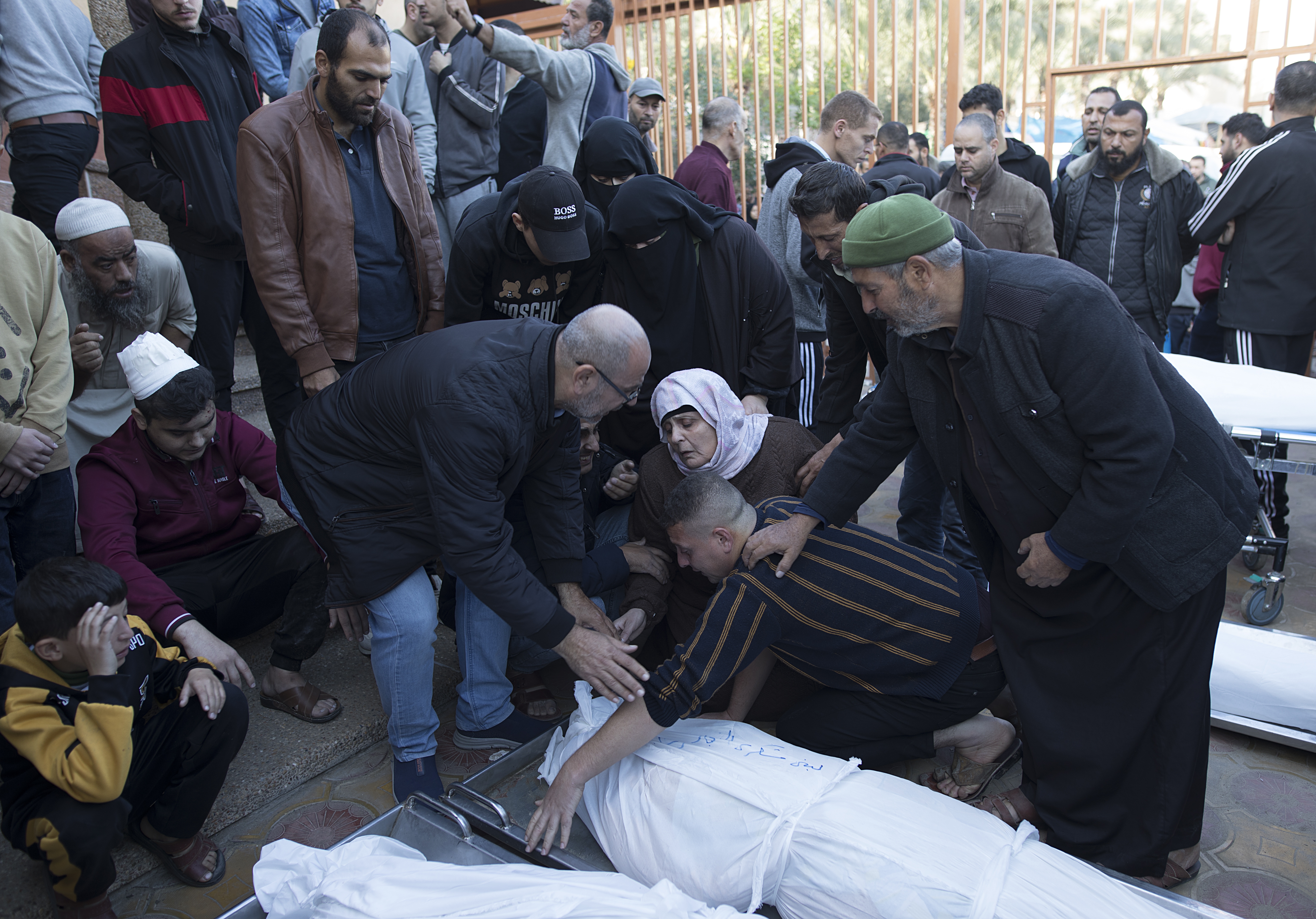 Relatives of Palestinians from the Sharab family, who died during Israeli air strikes in the southern Gaza Strip, mourn next to their wrapped bodies, outside Nasser Hospital in Khan Yunis, southern Gaza Strip, 04 December 2023