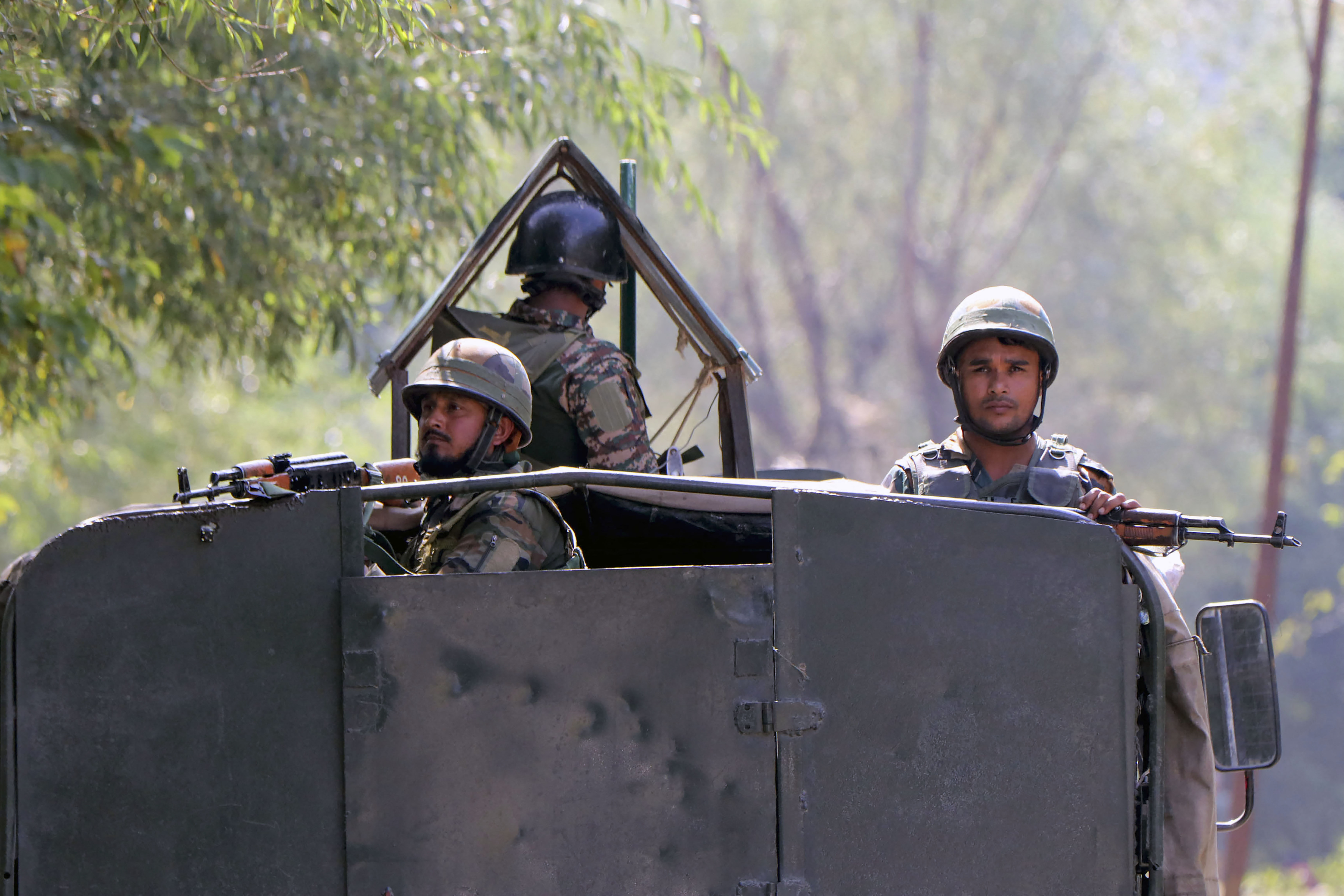 Indian army soldiers stand guard atop an armoured vehicle in south Kashmir's Anantnag district