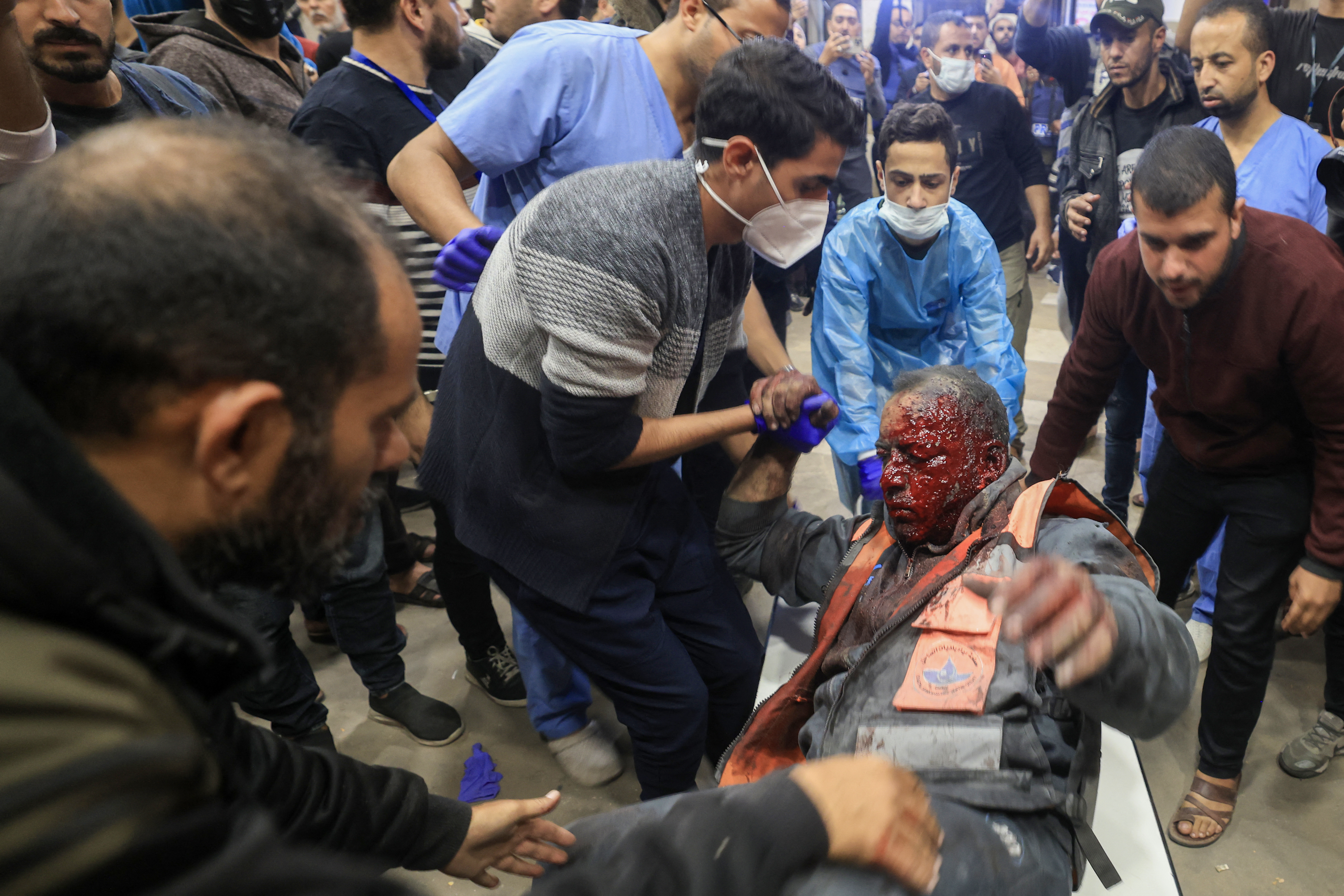 A Palestinian paramedic that was wounded during Israeli bombardment is helped onto a stretcher at Nasser hospital in Khan Yunis in the southern Gaza Strip on December 4