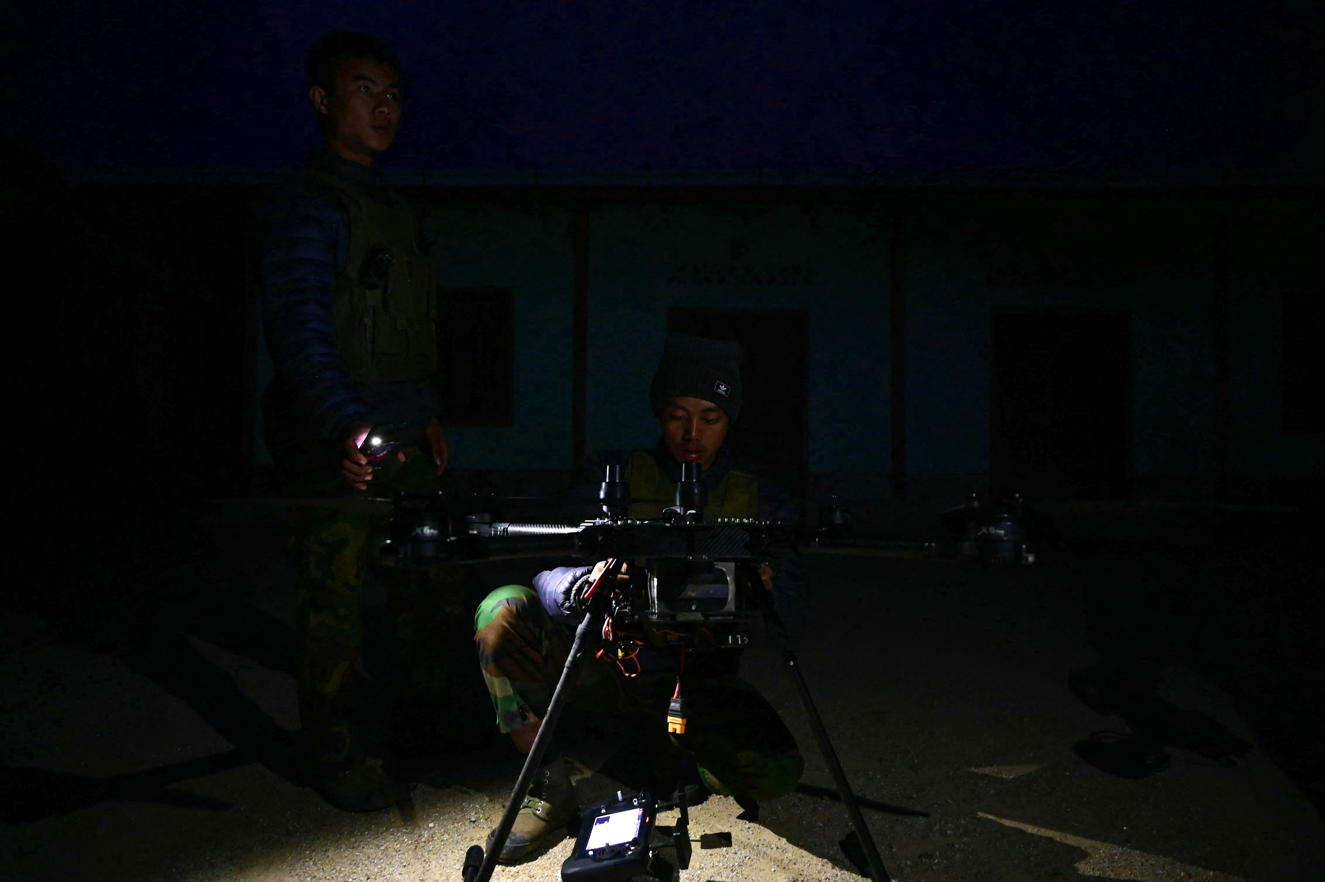 This photo taken on December 12, 2023 shows members of ethnic minority armed group Ta'ang National Liberation Army (TNLA) preparing to launch a drone during their attack on Myanmars military camp in Namhsan Township in Myanmar's northern Shan State.