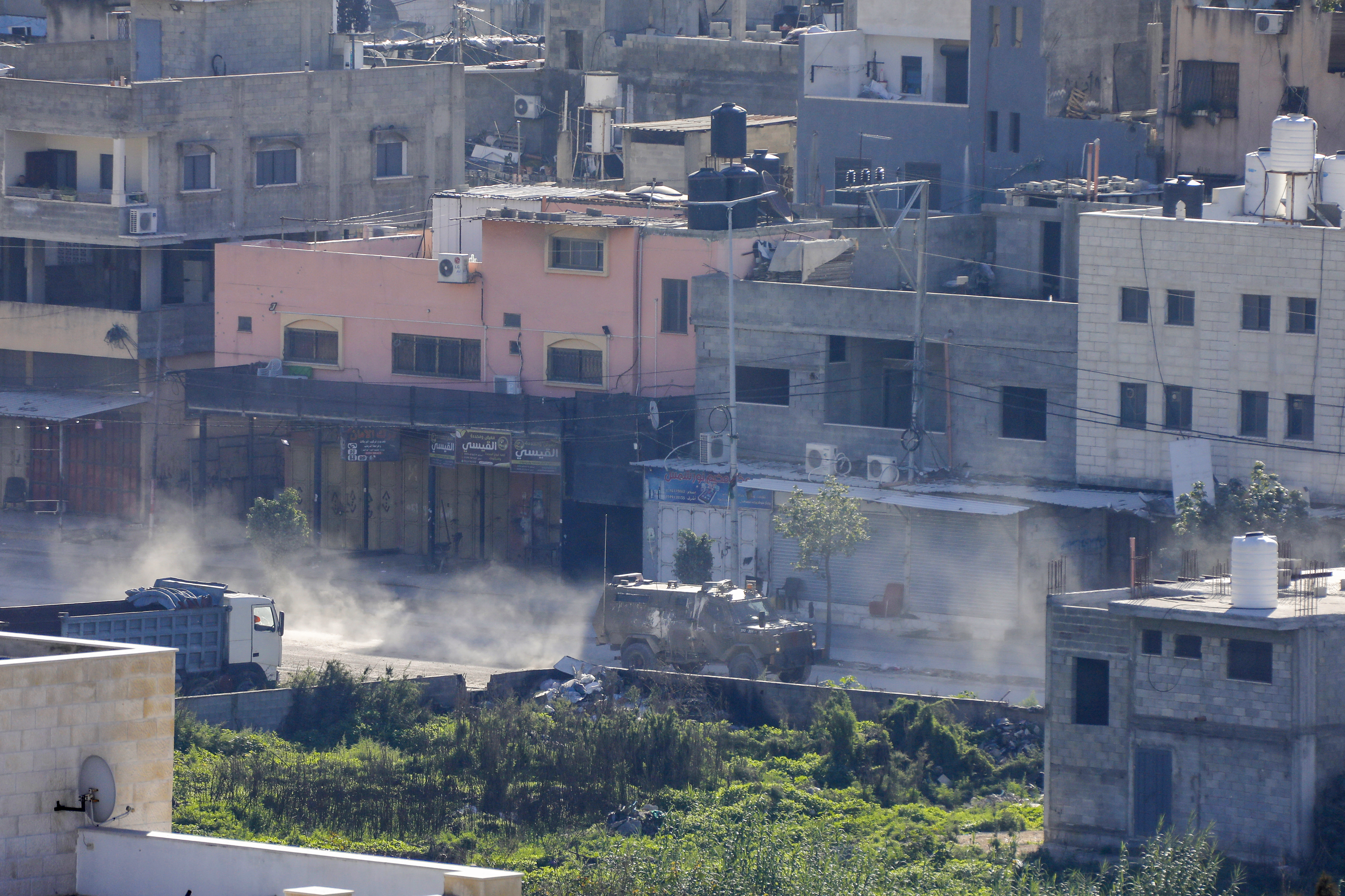 Israeli military vehicles drive down a road as they retreat following a raid at the Nur Shams camp for Palestinian refugees near the northern city of Tulkarm in the occupied West Bank on December 17