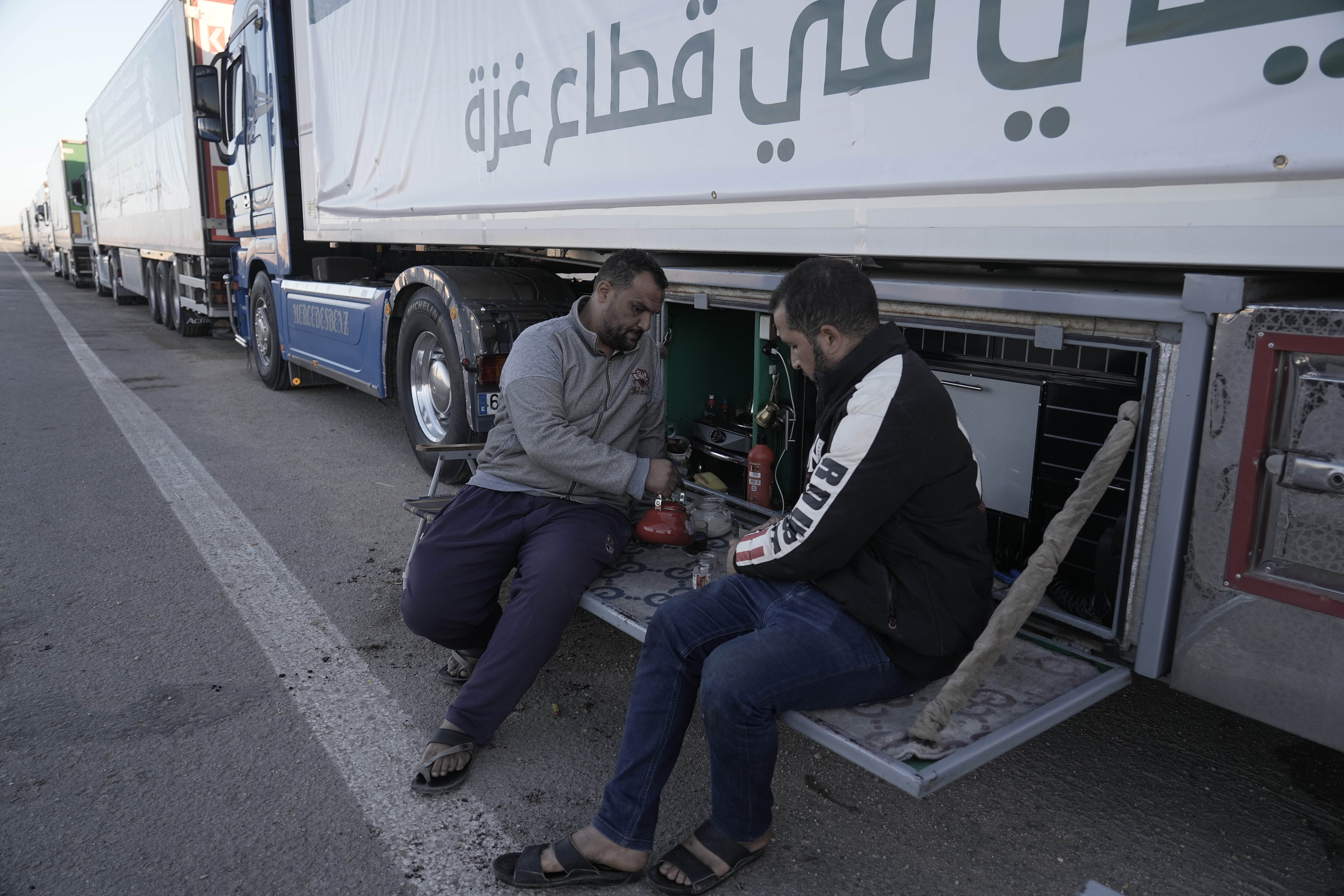 Humanitarian aid truck drivers drink tea as they wait to cross Rafah border crossing to Gaza Strip, Wednesday, Nov. 29, 2023. (AP Photo/Amr Nabil)