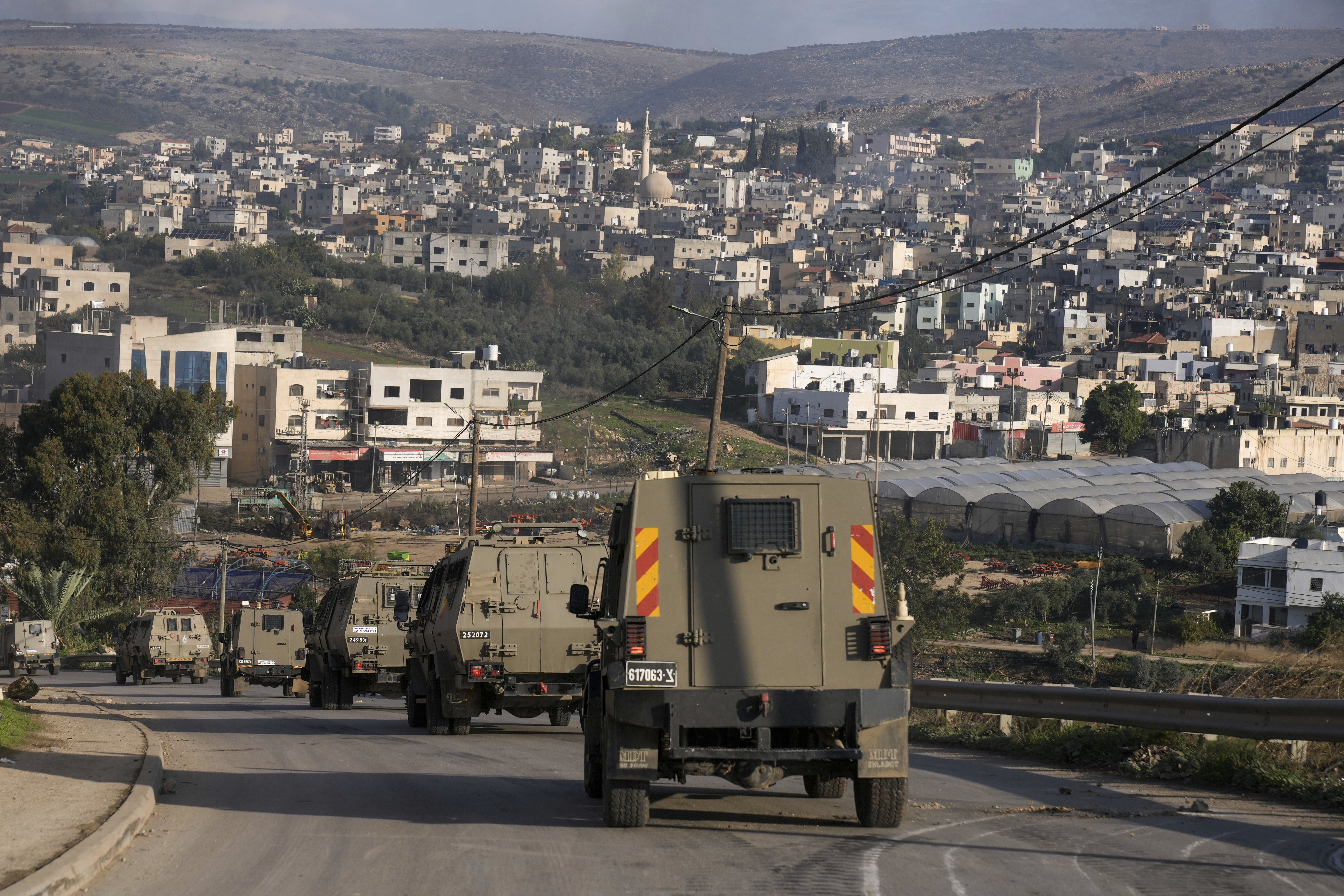 A convoy of Israeli army vehicles is seen during a military raid into Faraa refugee camp, West Bank