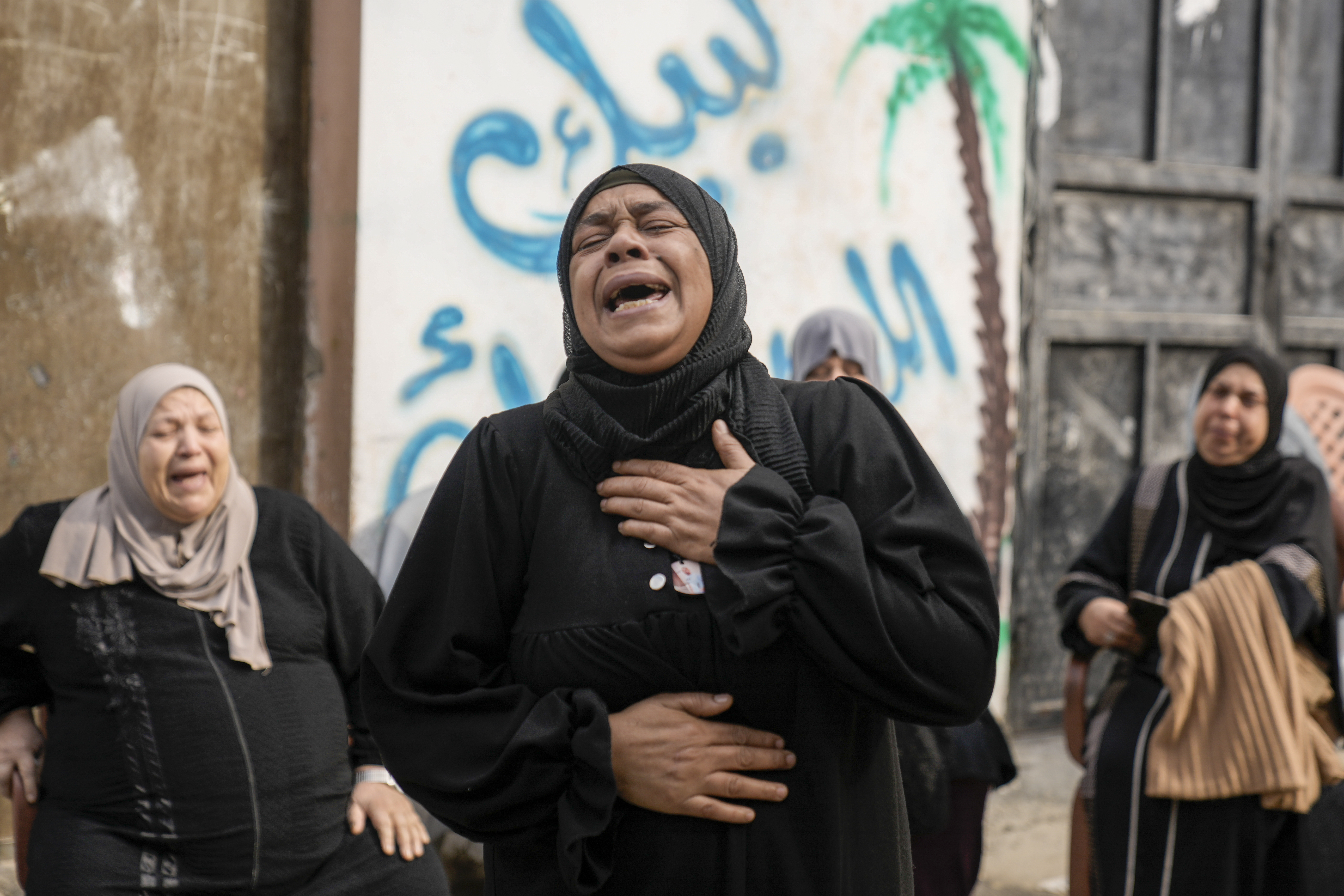 Palestinian women mourn after an Israeli military raid on Nur Shams refugee camp in the West Bank