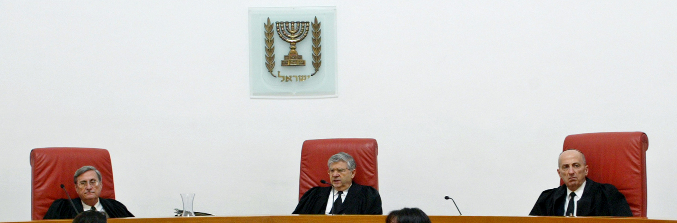 Aharon Barak (C), Israel's Supreme Court Chief Justice, opens hearings in Jerusalem February 9, 2004. Israel's Supreme Court opened hearings on Monday into the legality of a West Bank barrier the government says stops suicide bombers but which civil liberties groups say causes Palestinian hardship. REUTERS/Gil Cohen Magen GCM/GM/JV/AA
