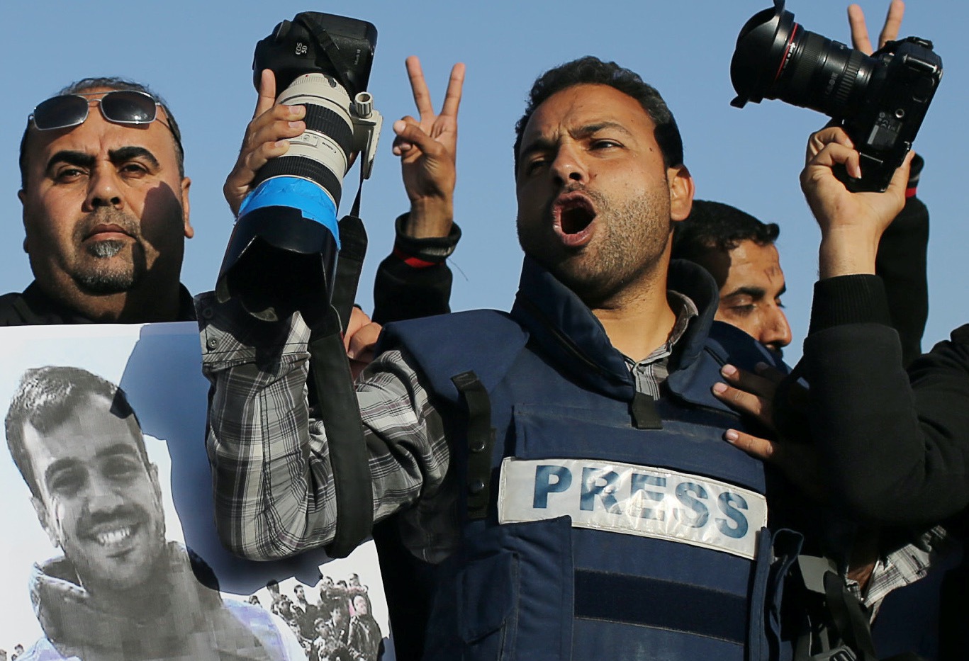 Journalists take part in a protest against the killing of Palestinian journalist Yasser Murtaja