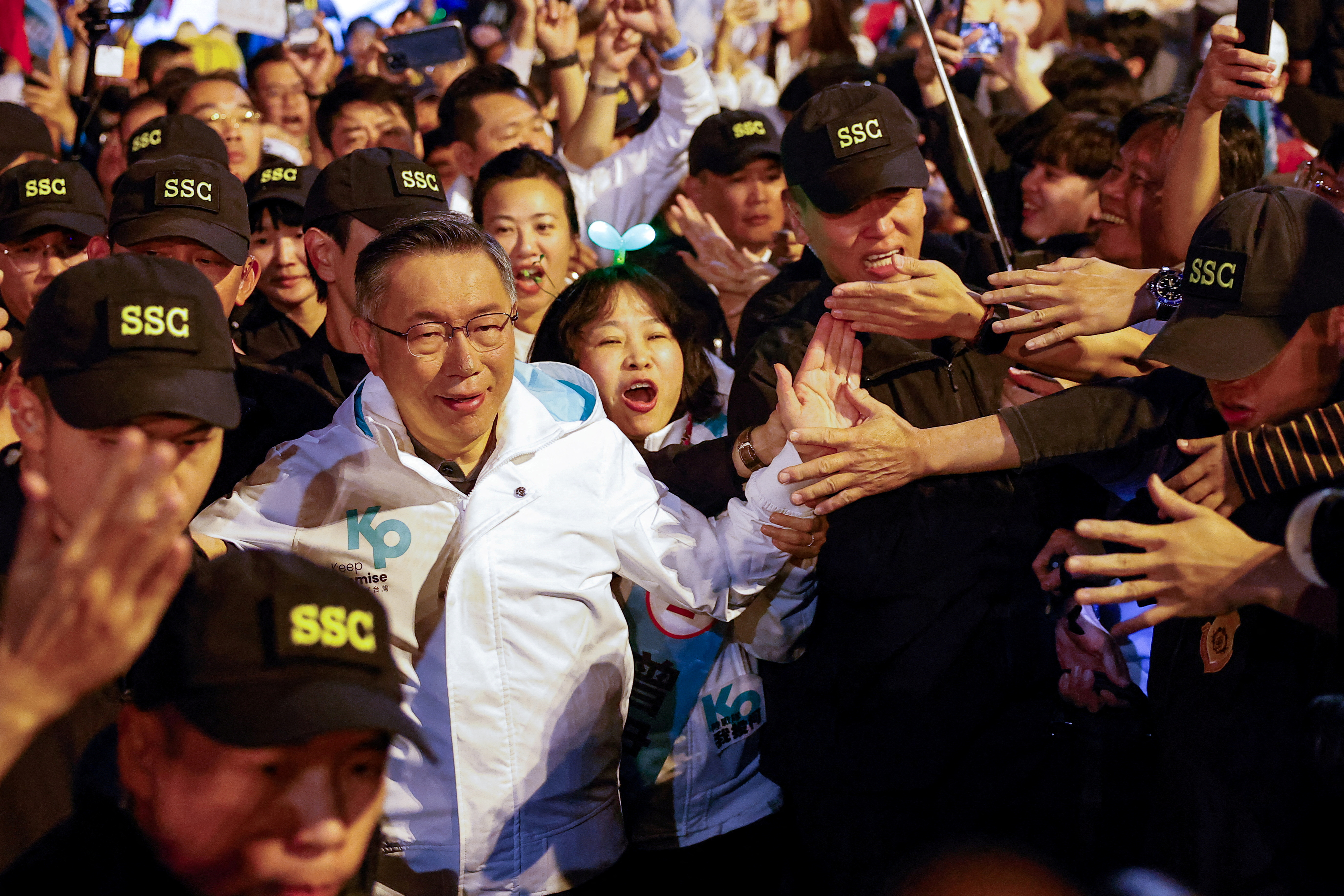 Ko Wen-je, Taiwan People's Party (TPP) presidential candidate. He is wearing a white jacket and walking through a crowd of supporters