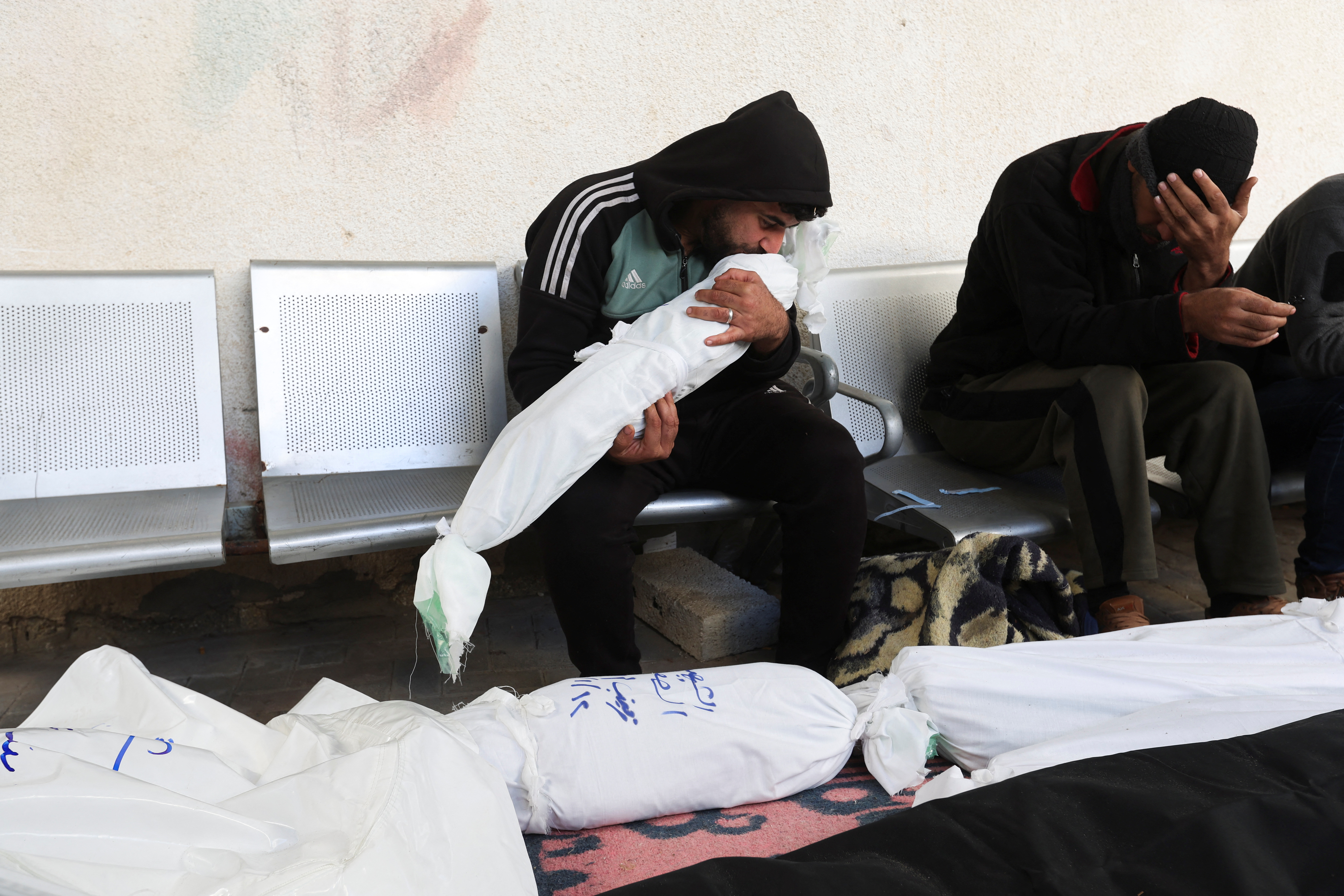 A man kisses the body of a Palestinian child killed in an Israeli strike, amid the ongoing conflict between Israel and the Palestinian Islamist group Hamas, at Abu Yousef al-Najjar hospital, in Rafah in the southern Gaza Strip, January 13, 2024. REUTERS/Ibraheem Abu Mustafa