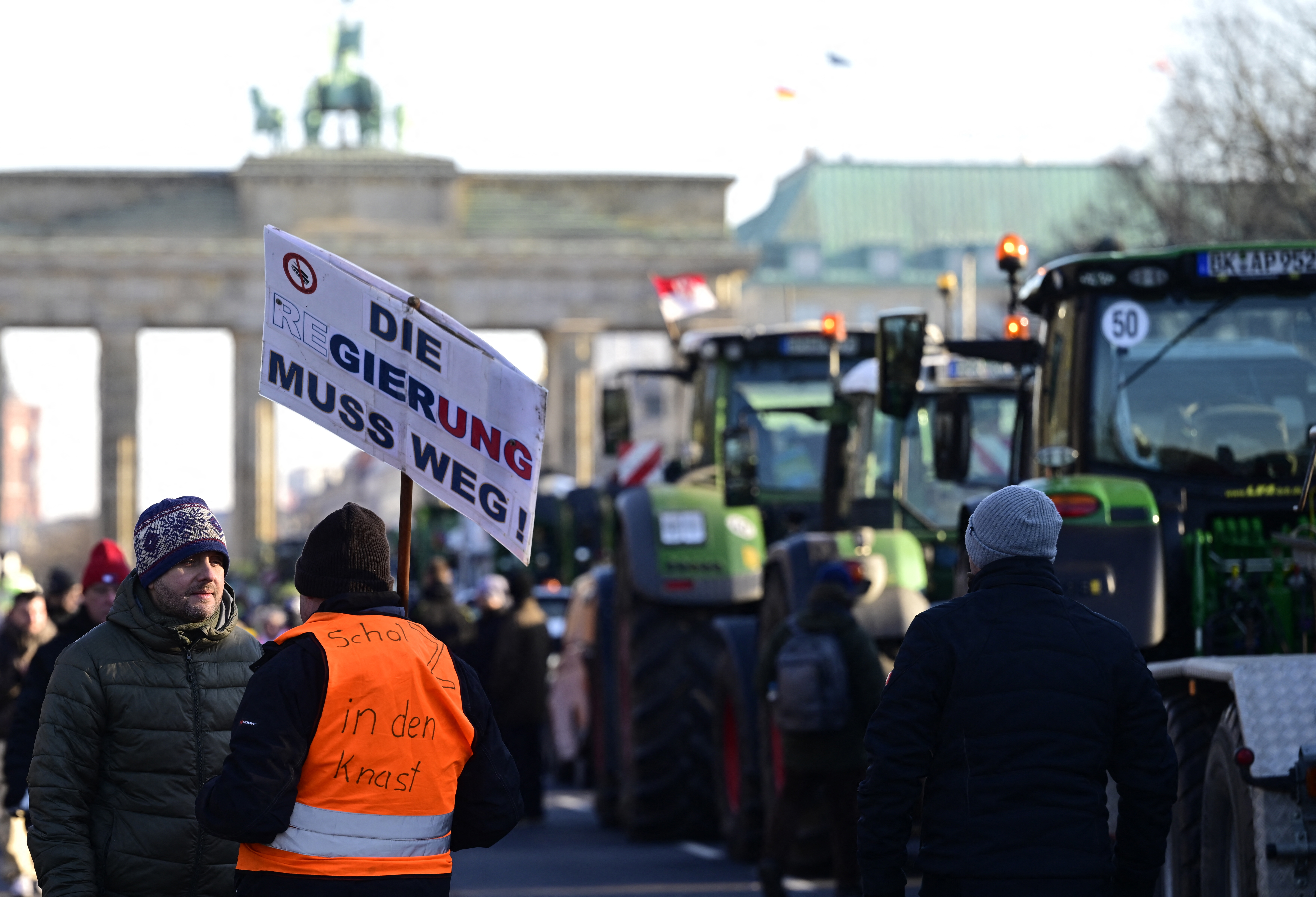 A demonstrator holds a placard reading 'The government must go away'