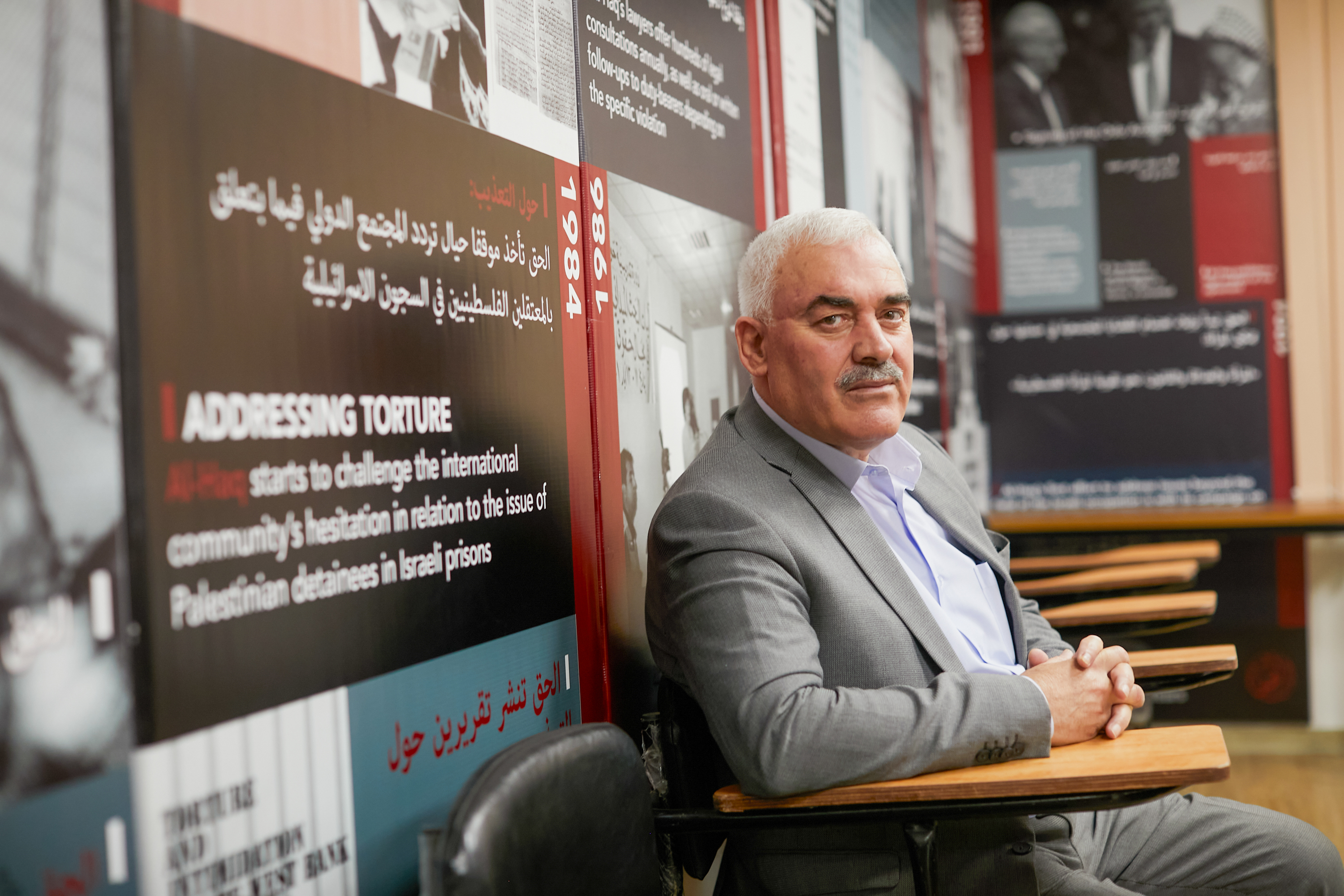 Shawan in grey suit looking at camera sideways