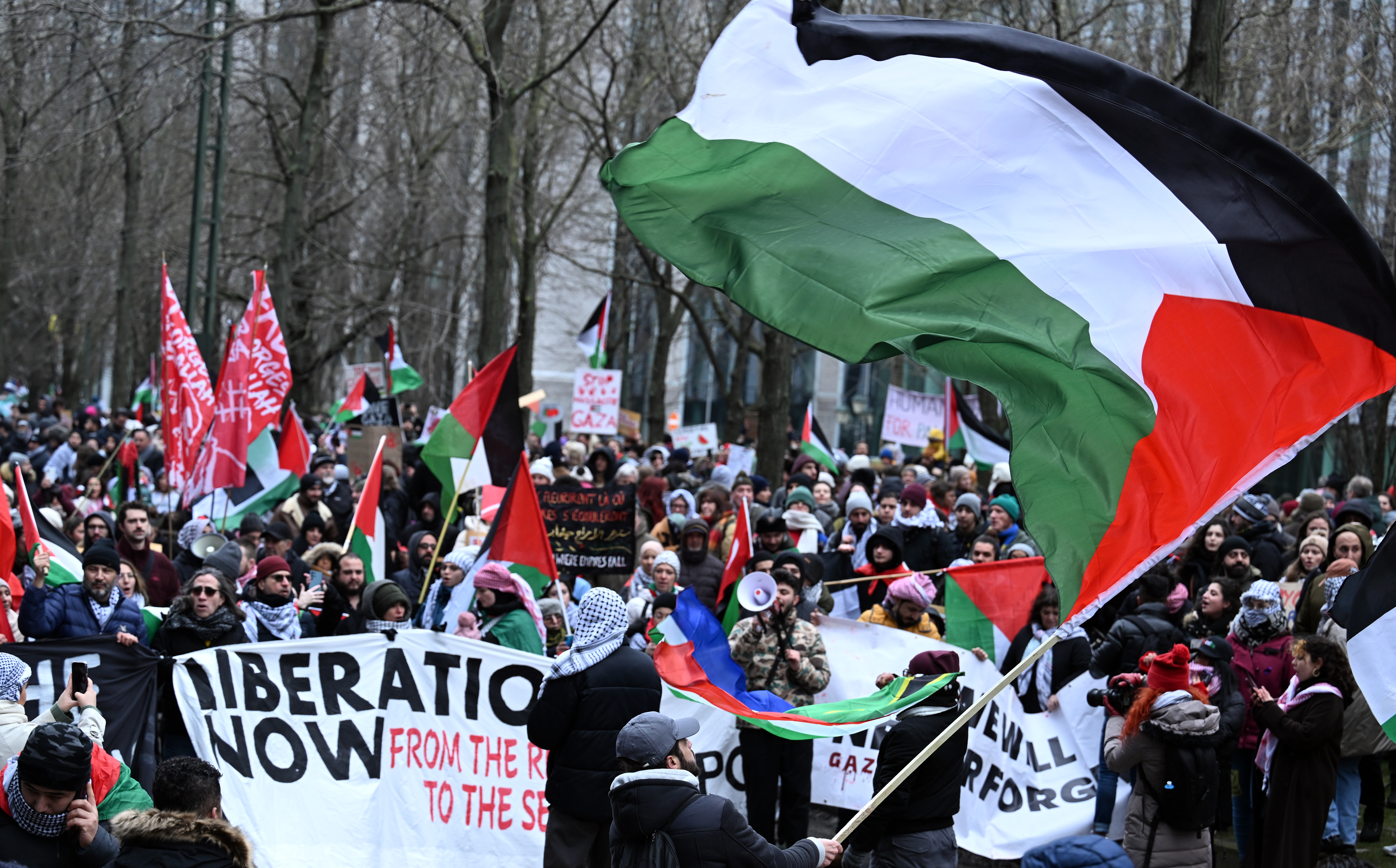 Protesters waving a large Palestinian flag
