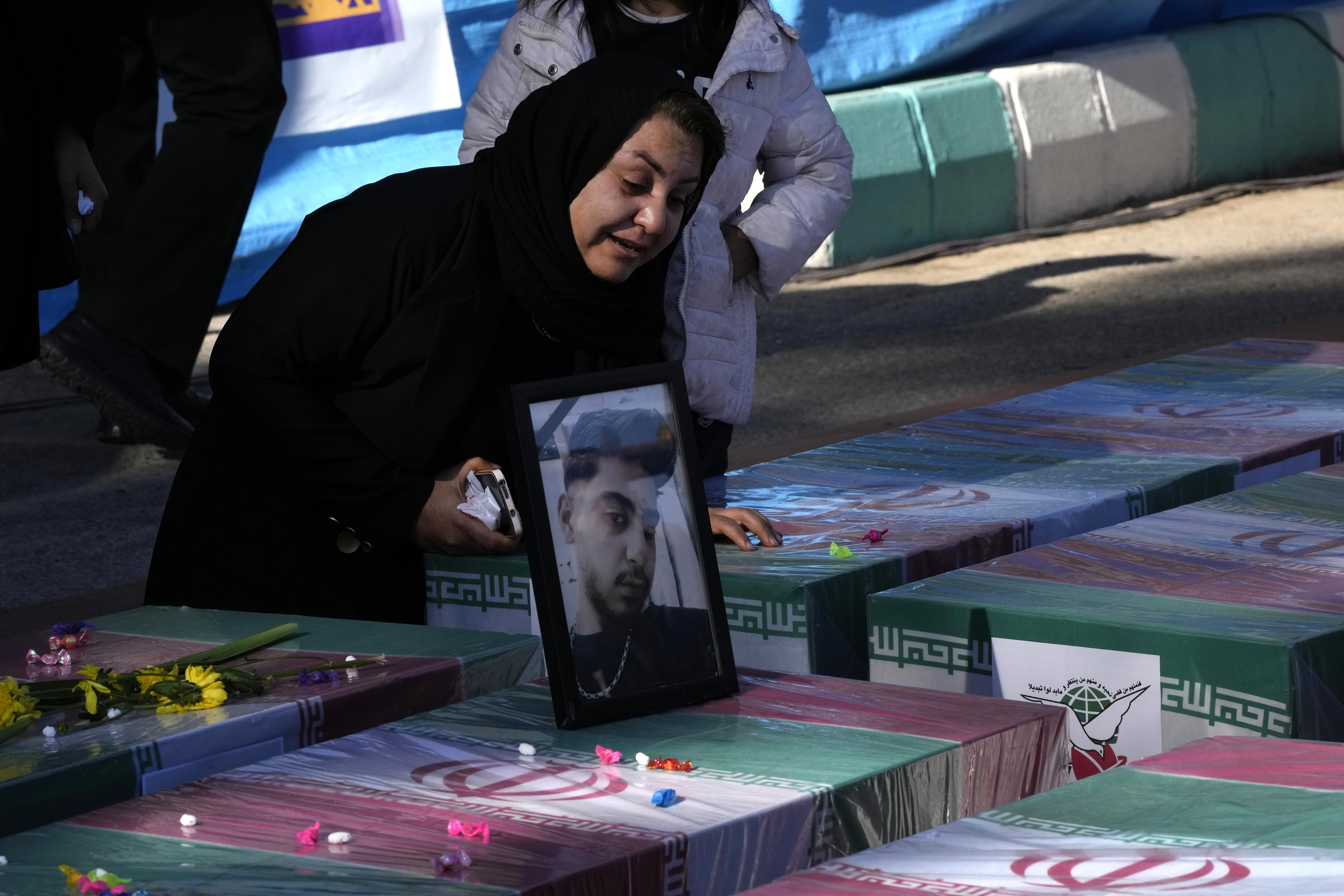 A woman mourns over the flag-draped coffin of her son who was killed in Wednesday's bomb explosion