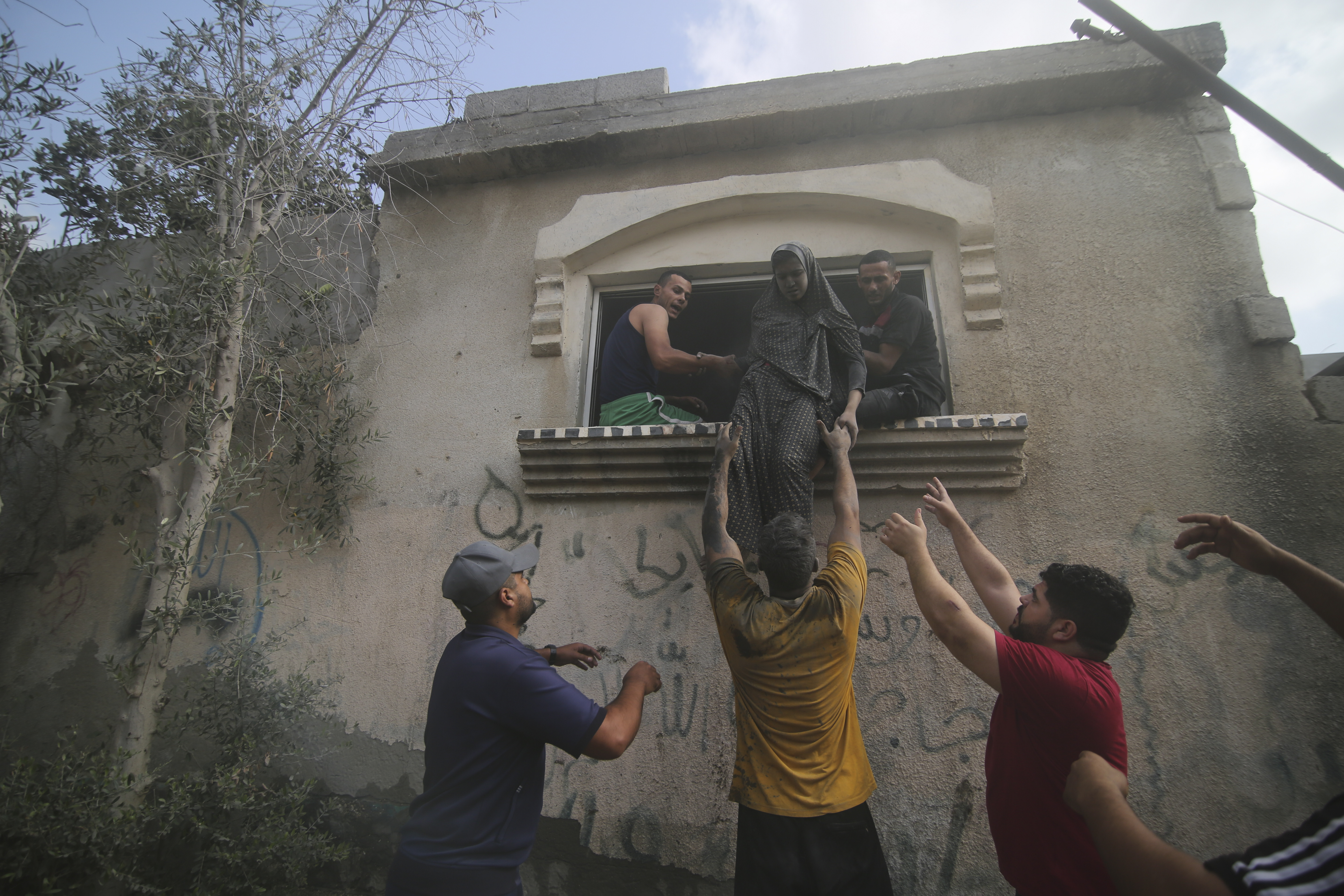 Palestinians evacuate a building hit in the Israeli bombardment of the Gaza Strip in Rafah