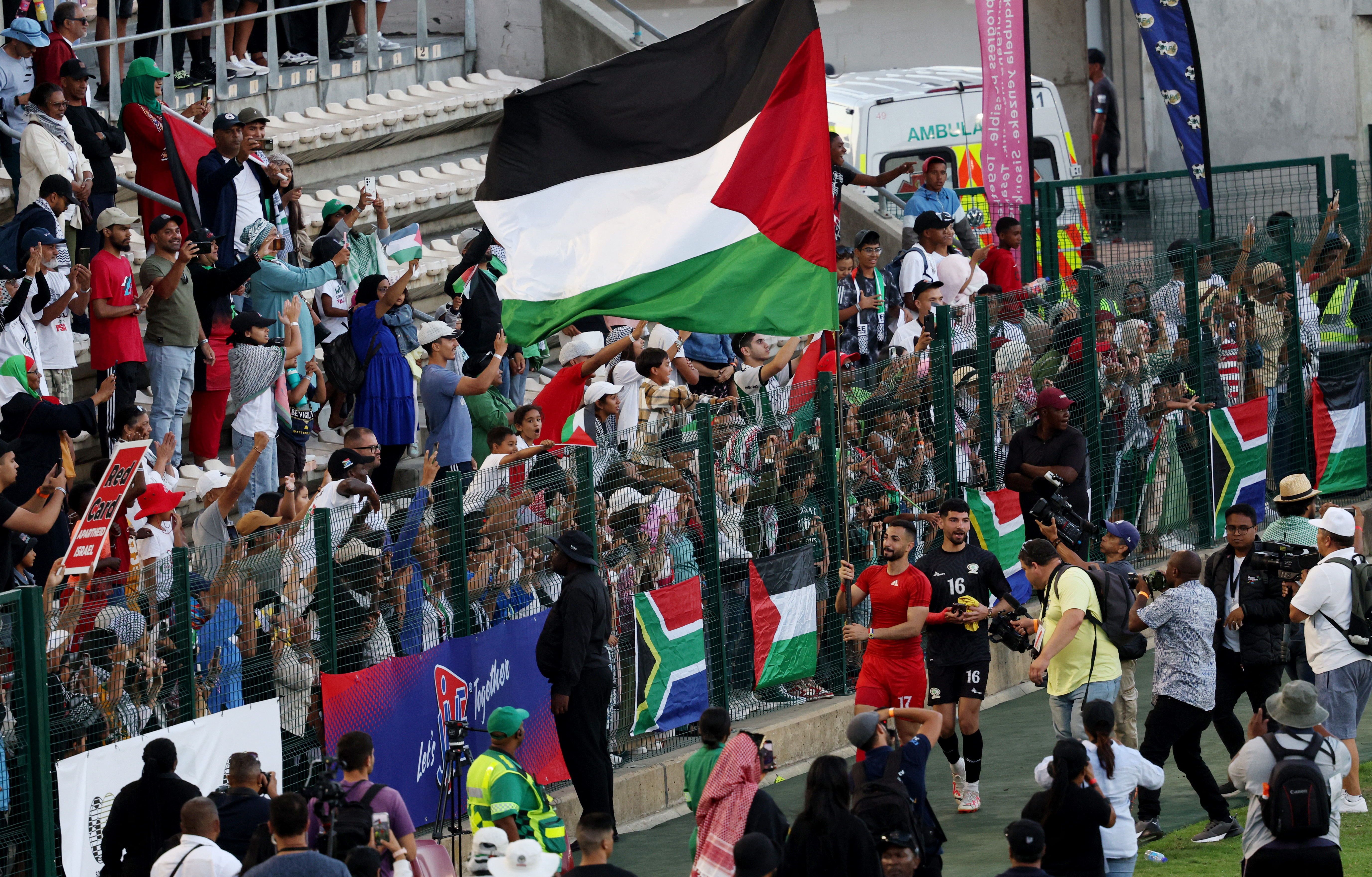 Palestinian footballer Bashar al-Shobaki and fans display flags after a friendly match in Cape Town, South Africa [Esa Alexander/Reuters]
