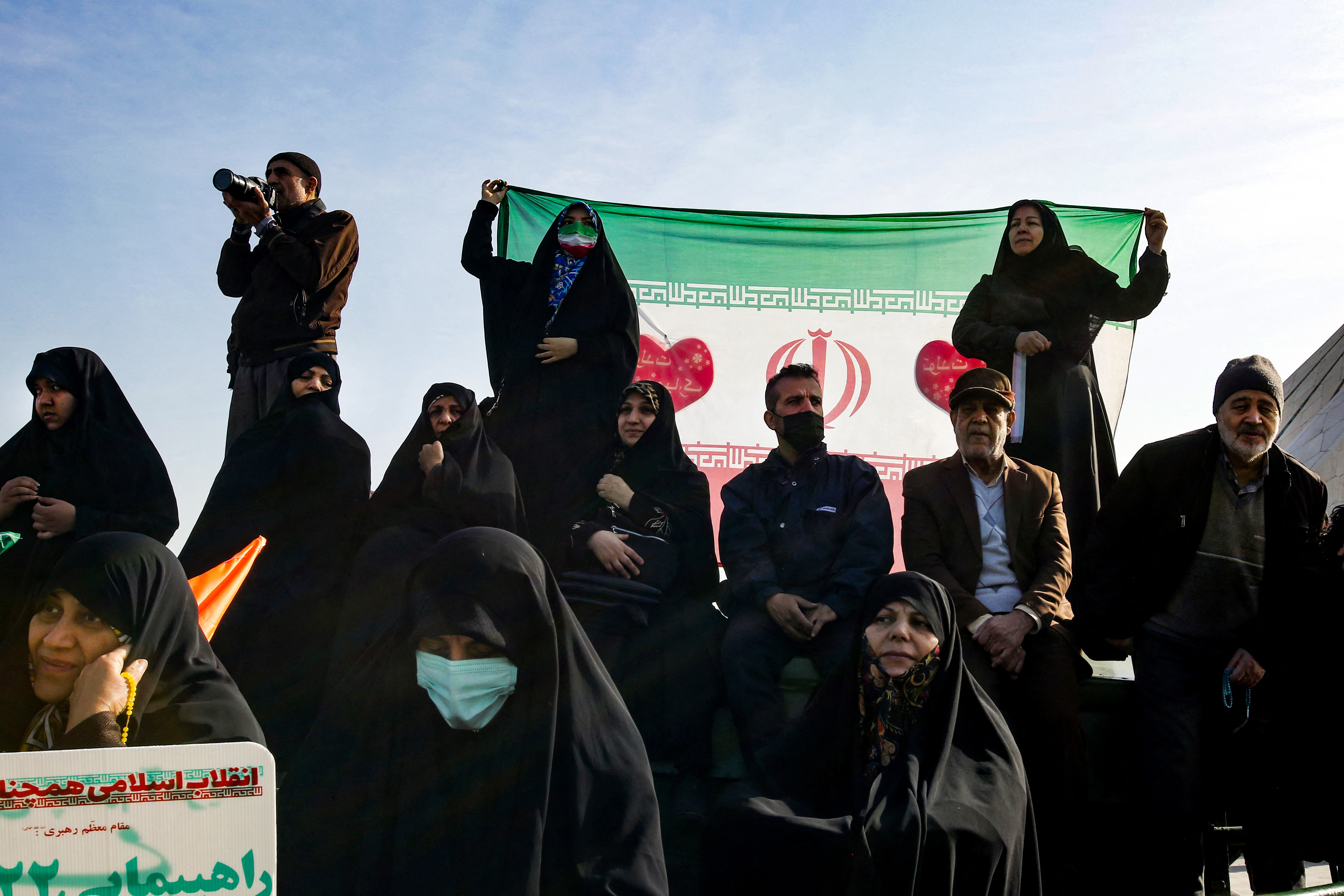 People deploy the Iranian national flag as they gather to mark the 45th anniversary of the Islamic revolution in Tehran