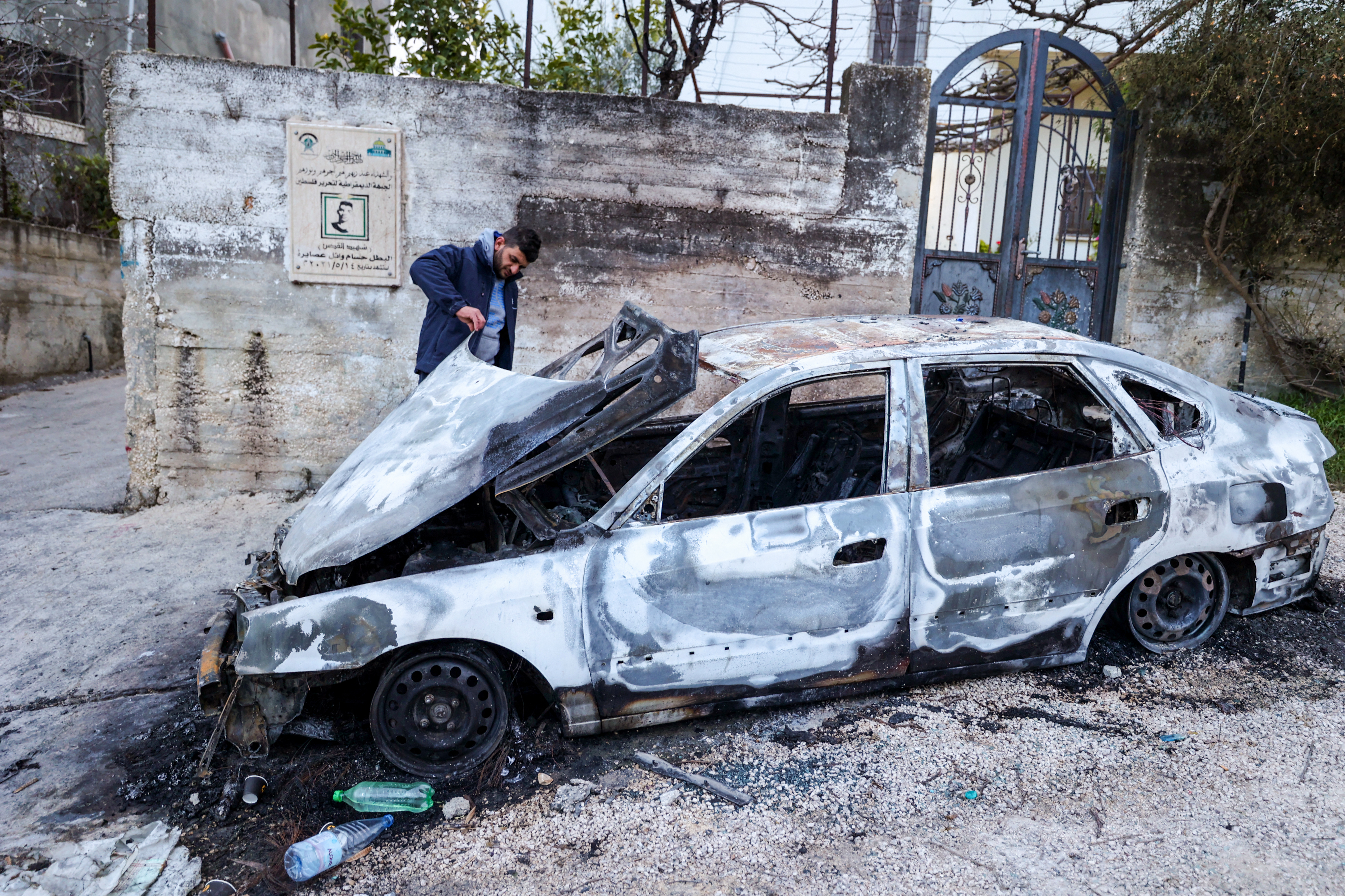A Palestinian man inspects a car damaged