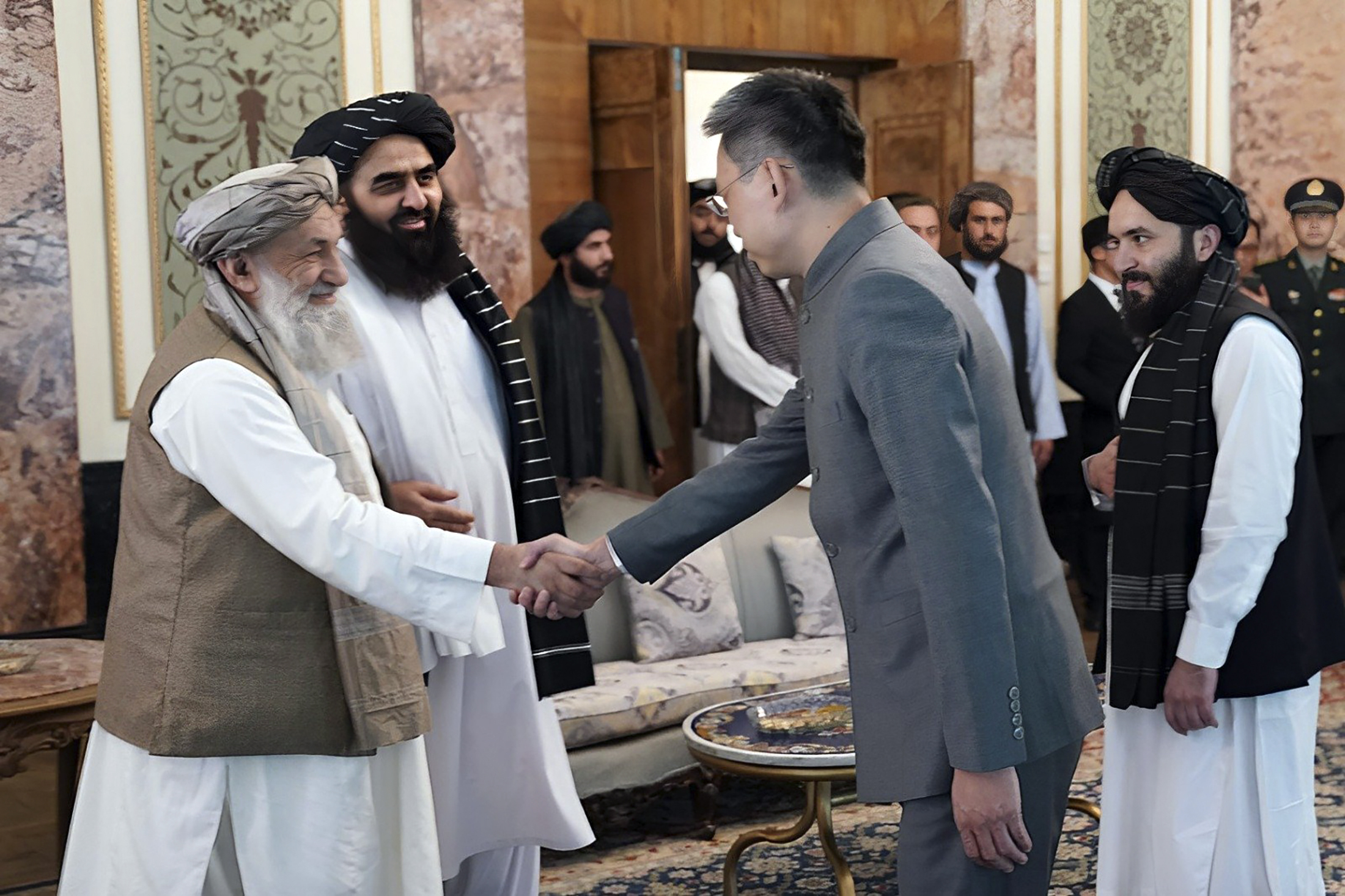 In this handout photo released by Taliban Prime Minister Media Office, China's new ambassador to Afghanistan Zhao Sheng shakes hand with Taliban Prime Minister Mohammad Hasan Akhund, left, during the recognition ceremony at the Presidential Palace, in Kabul, Afghanistan, Wednesday, Sept. 13, 2023. The Taliban on Wednesday greeted China's new ambassador to Afghanistan with pomp and ceremony, calling the envoy's nomination a significant step with a significant message. (Taliban Prime Minister Media Office via AP)