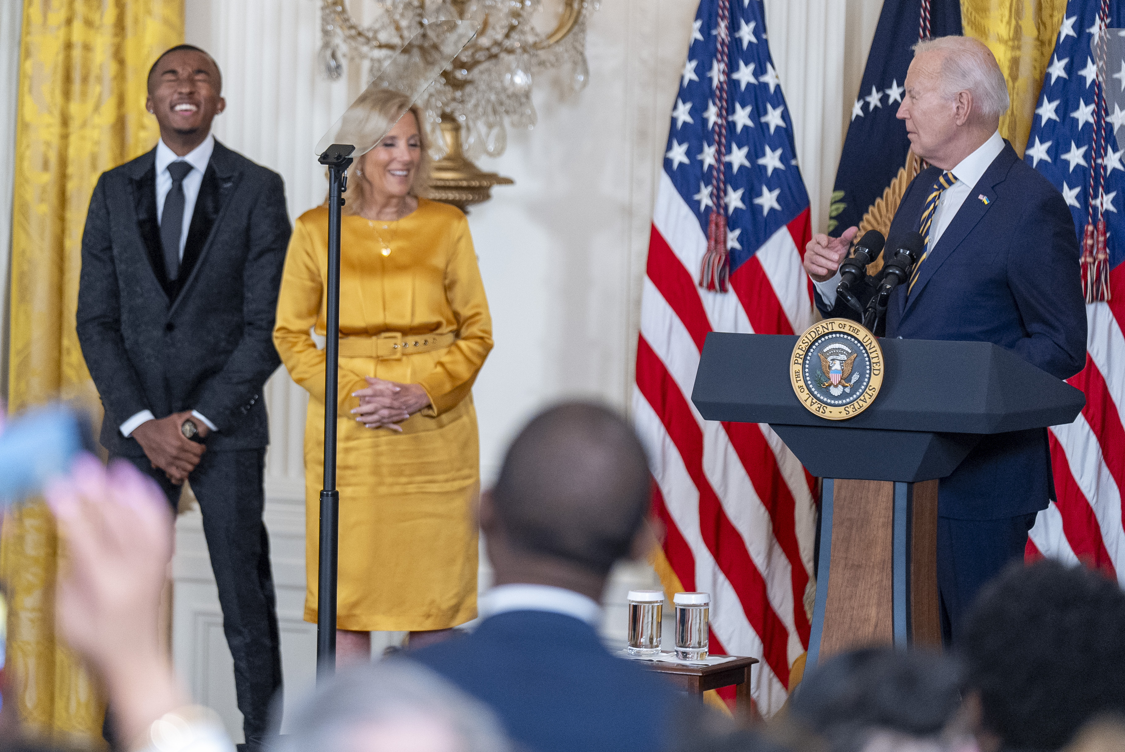Nijel Murray, left, and first lady Jill Biden, second from left, react to a joke from President Joe Biden as he speaks at a reception