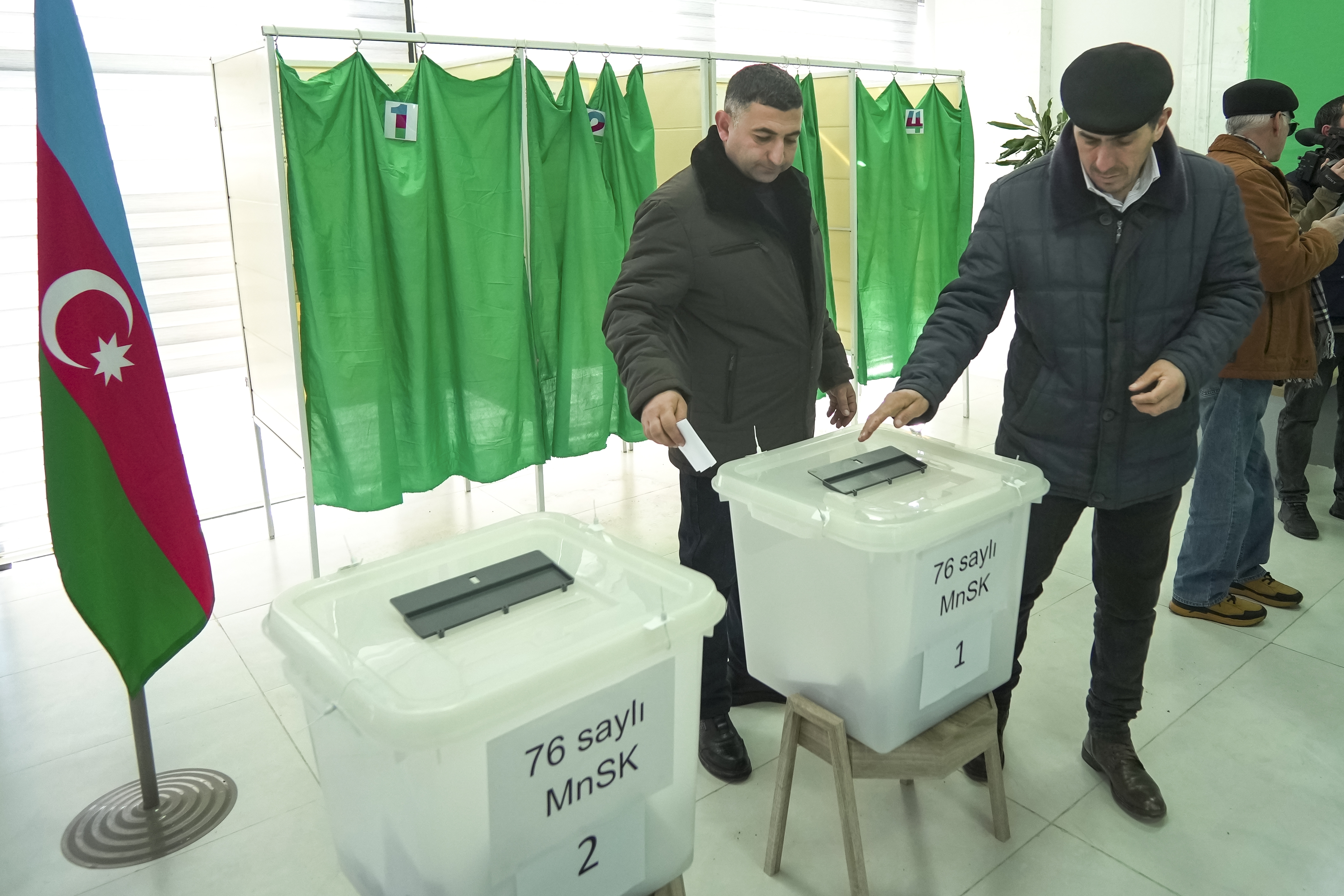 Men vote at a polling station during presidential election in Fuzuli, Karabakh region, Azerbaijan, Wednesday, Feb. 7, 2024. Azerbaijanis are voting Wednesday in an election almost certain to see incumbent President Ilhan Aliyev chosen to serve another seven-year term. (AP Photo/Sergei Grits)
