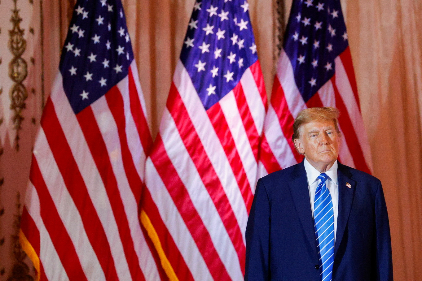 Trump against a row of US flags