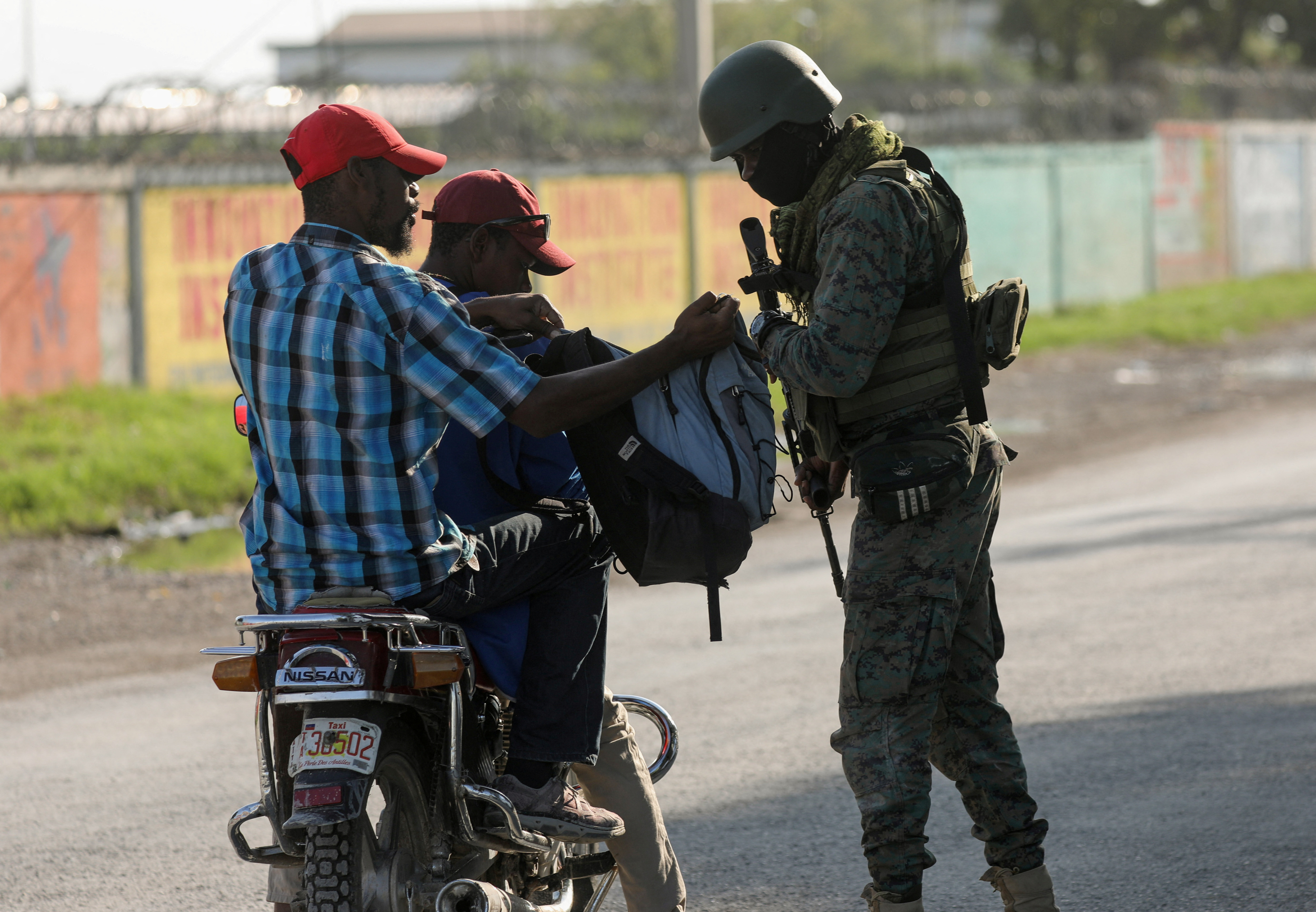 A soldier checks a bag for weapons in Haiti