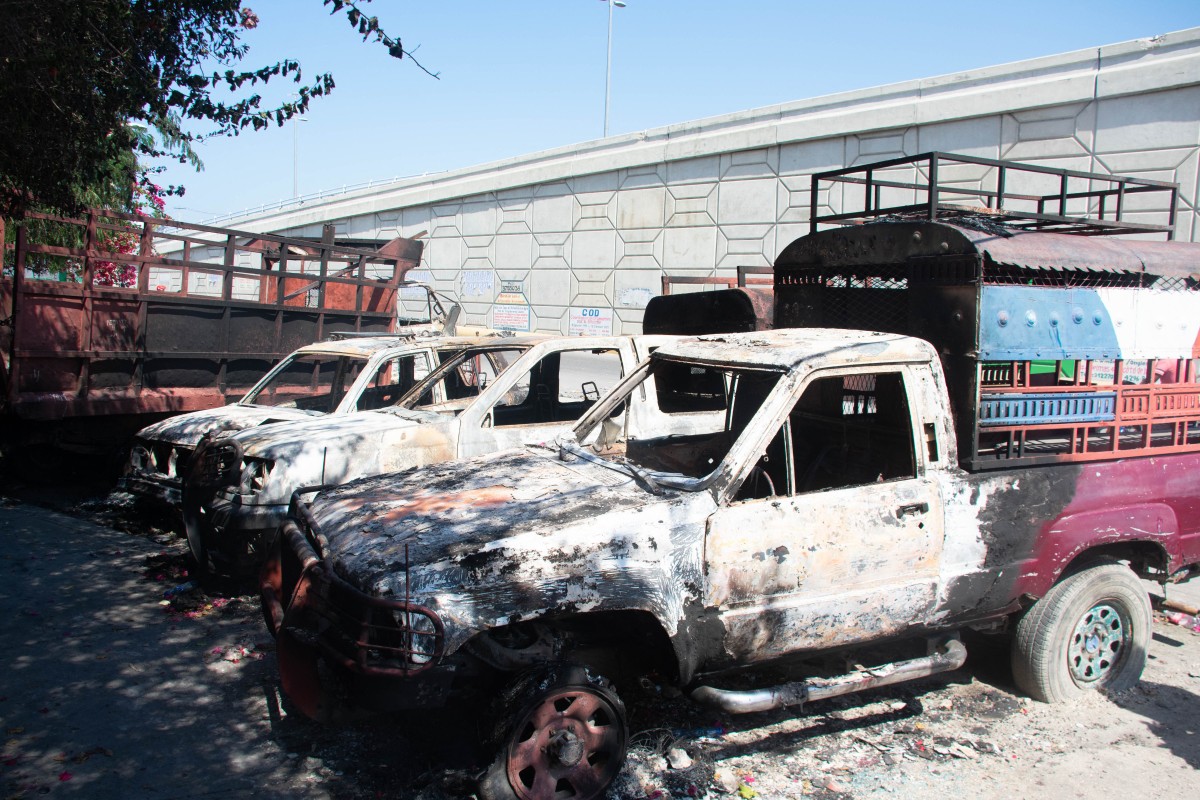 Carcasses of burnt-out vehicles are seen in front of the police station at Carrefour de lAeroport, in Port-au-Prince