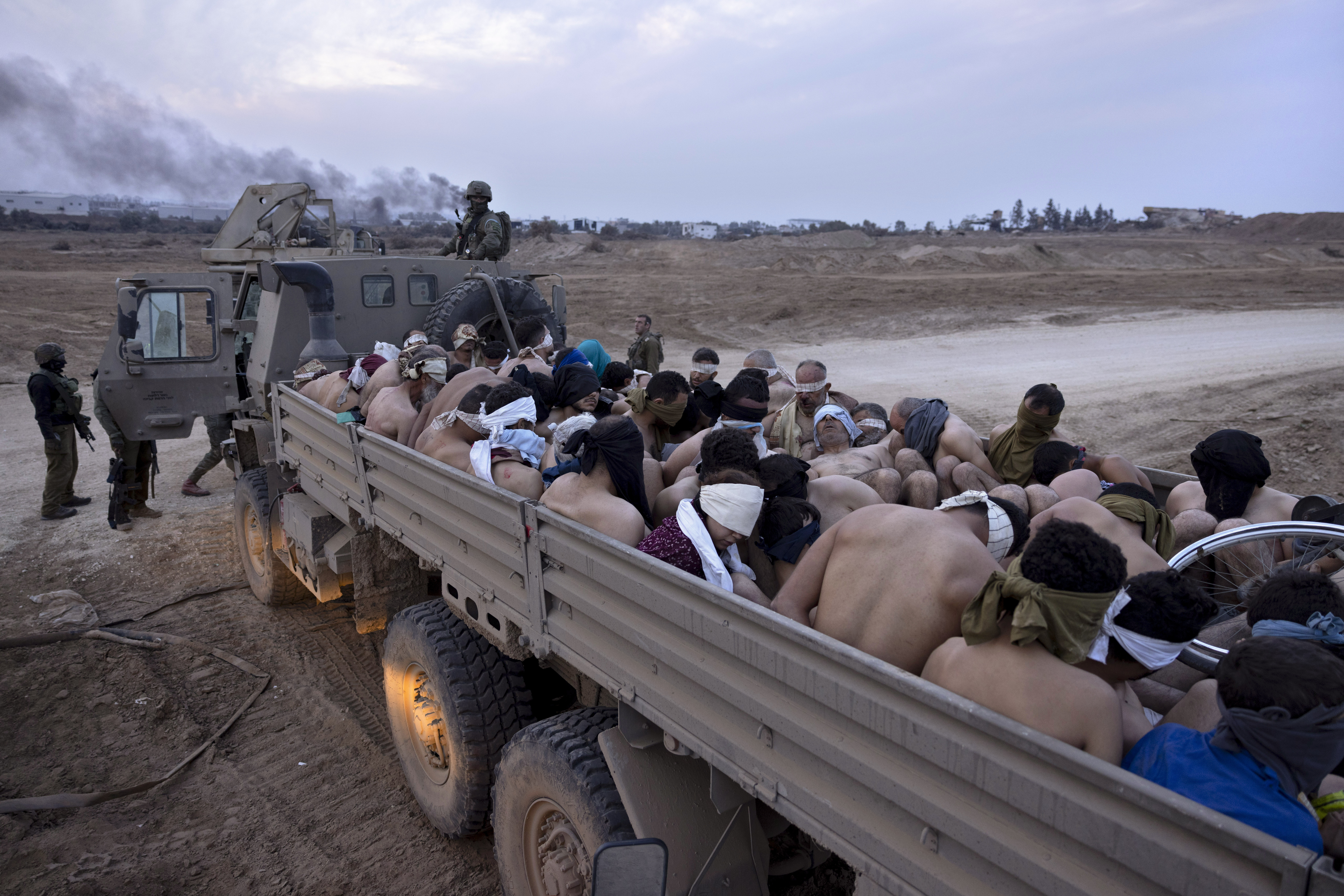 An Israeli truck full of stripped Palestinians thrown in, the wheel of what appears to be a wheelchair showing