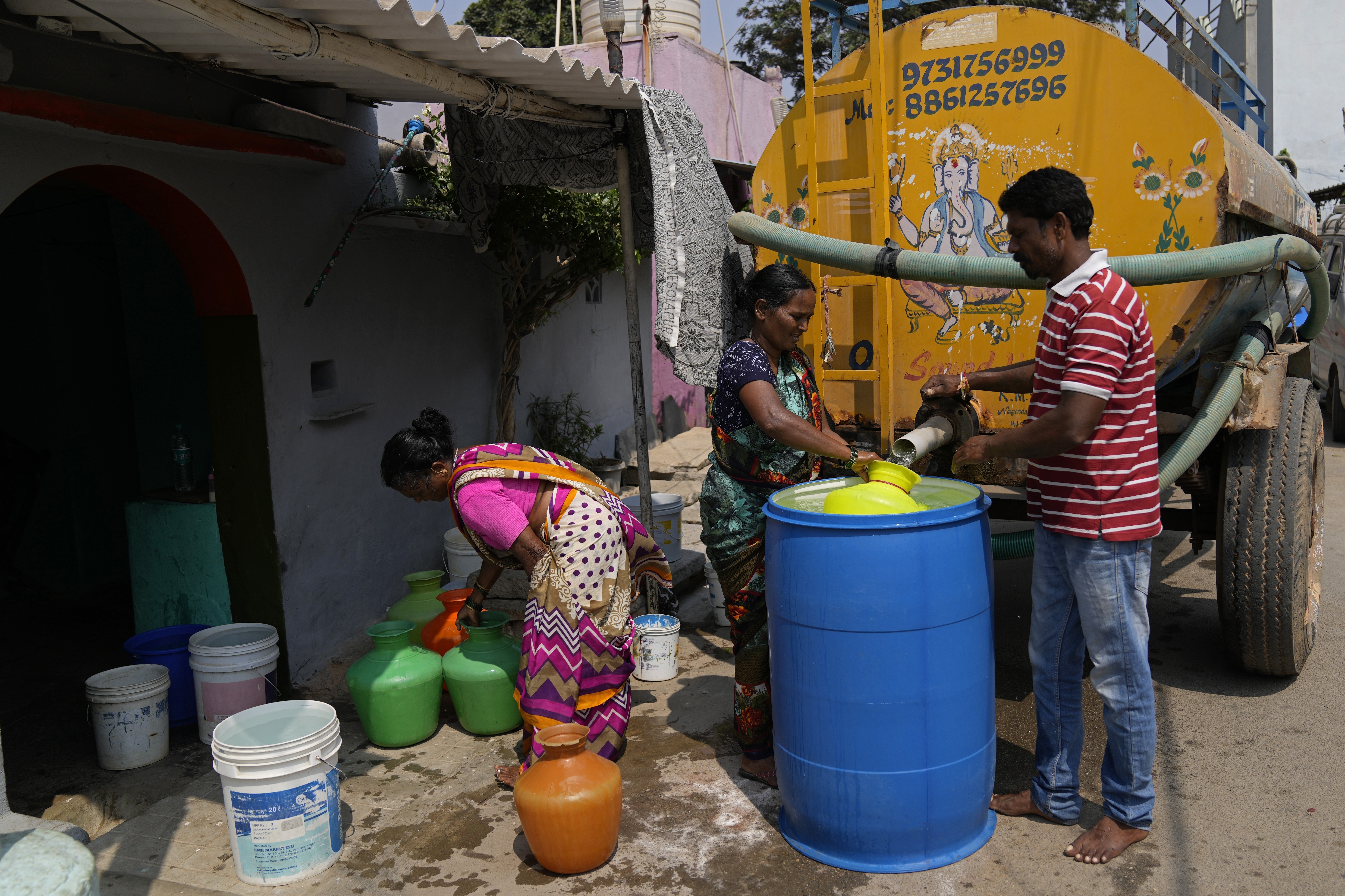 Residents of Ambedkar Nagar, a low-income settlement in the shadows of global software companies in Whitefield neighborhood, collect potable water from a private tanker in Bengaluru, India