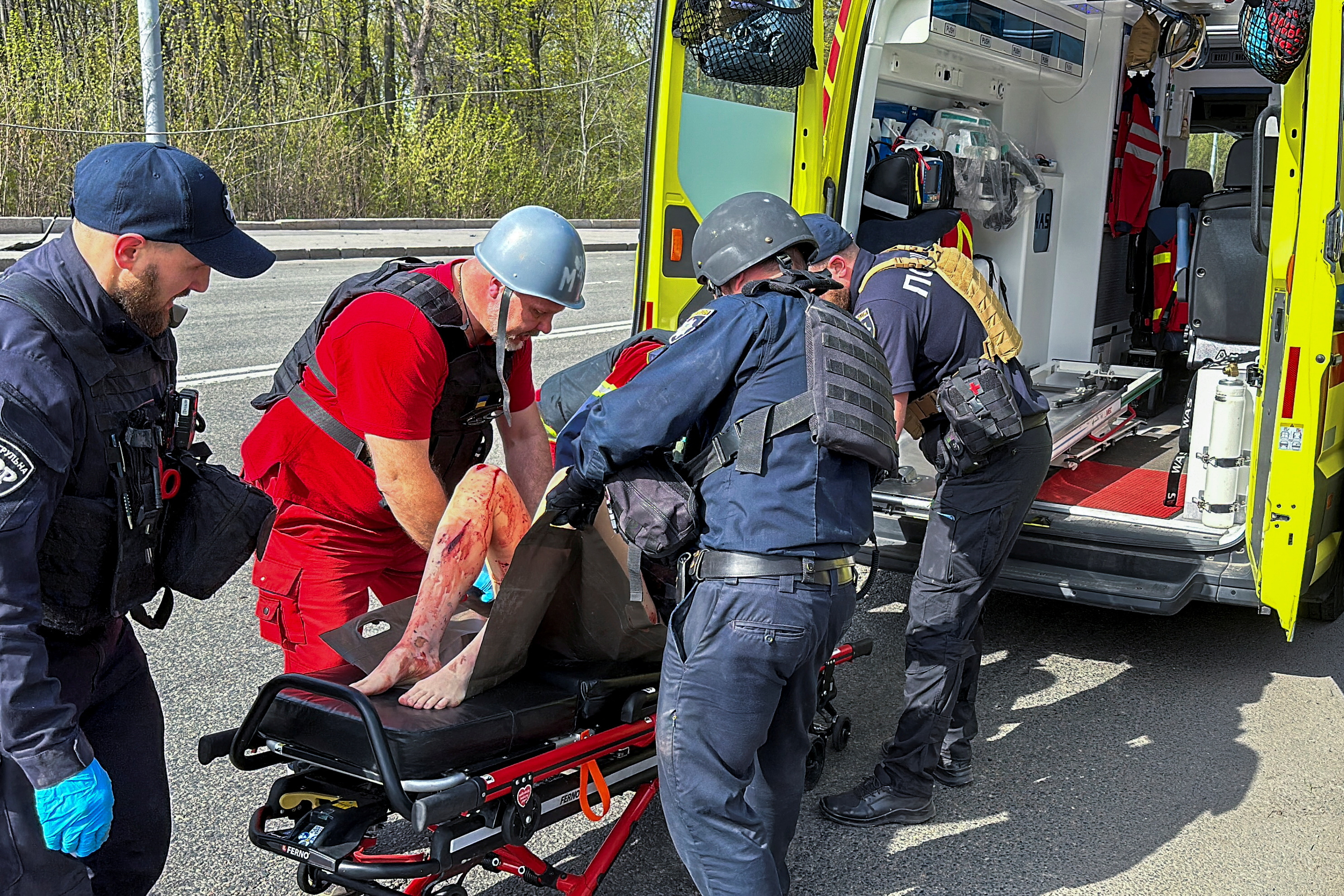 SENSITIVE MATERIAL. THIS IMAGE MAY OFFEND OR DISTURB Police officers and medical workers treat a wounded local resident after a Russian air strike, amid Russia's attack on Ukraine, in Kharkiv, Ukraine April 9, 2024. REUTERS/Vitalii Hnidyi