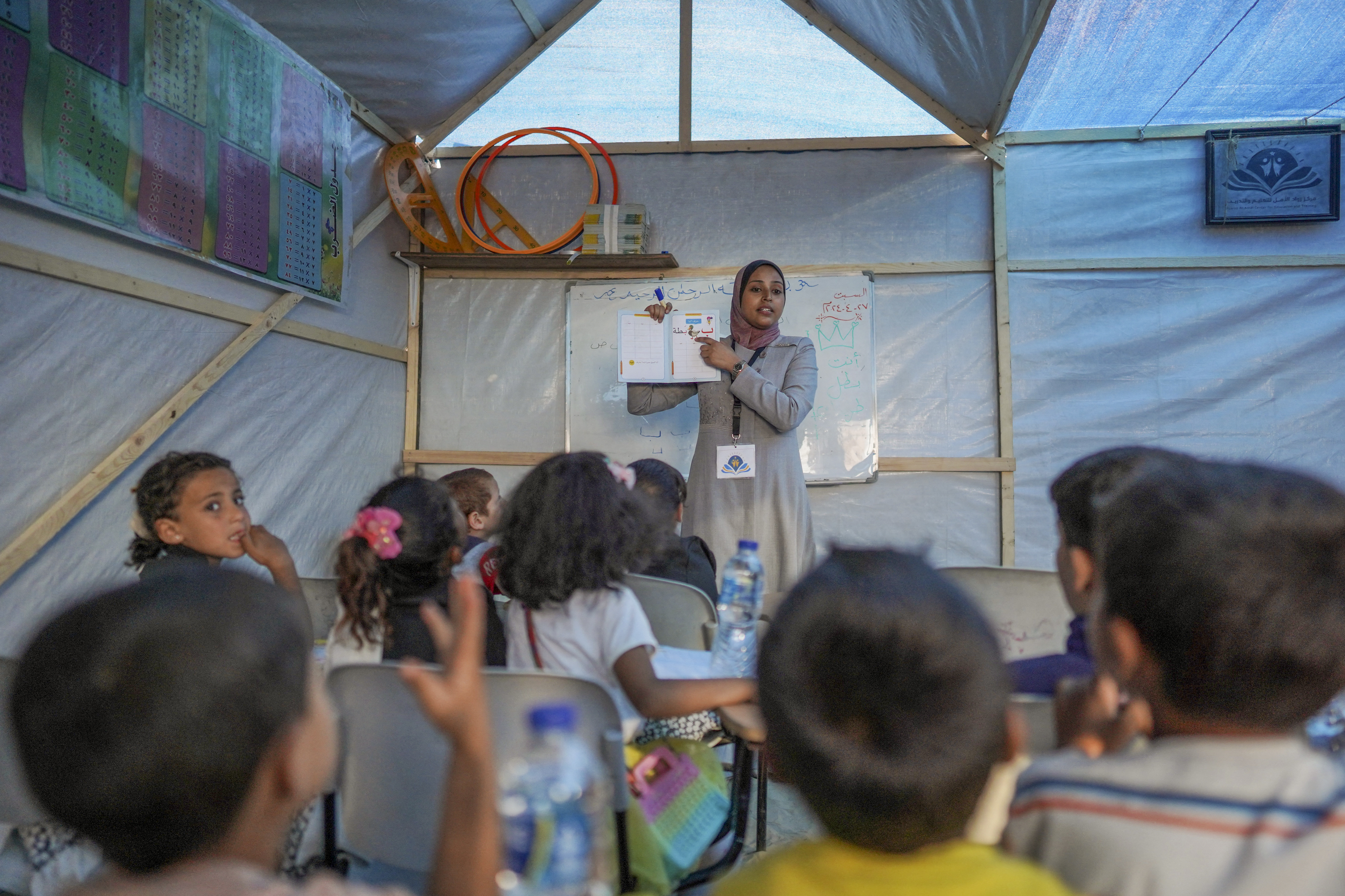 Children attend class at a makeshift school in a camp for displaced Palestinians in Deir El-Balah, in the central Gaza strip on April 27, 2024, amid the ongoing conflict between Israel and the militant Hamas group. (Photo by AFP)